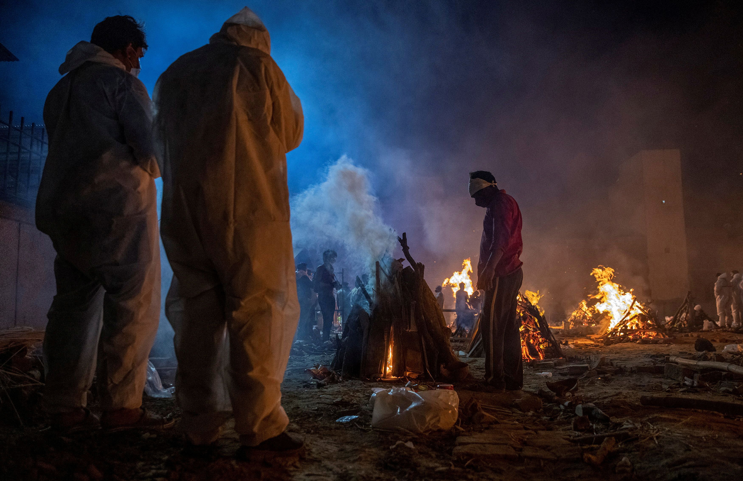 People cremate the body of a victim of the coronavirus disease at a crematorium ground in New Delhi on April 24