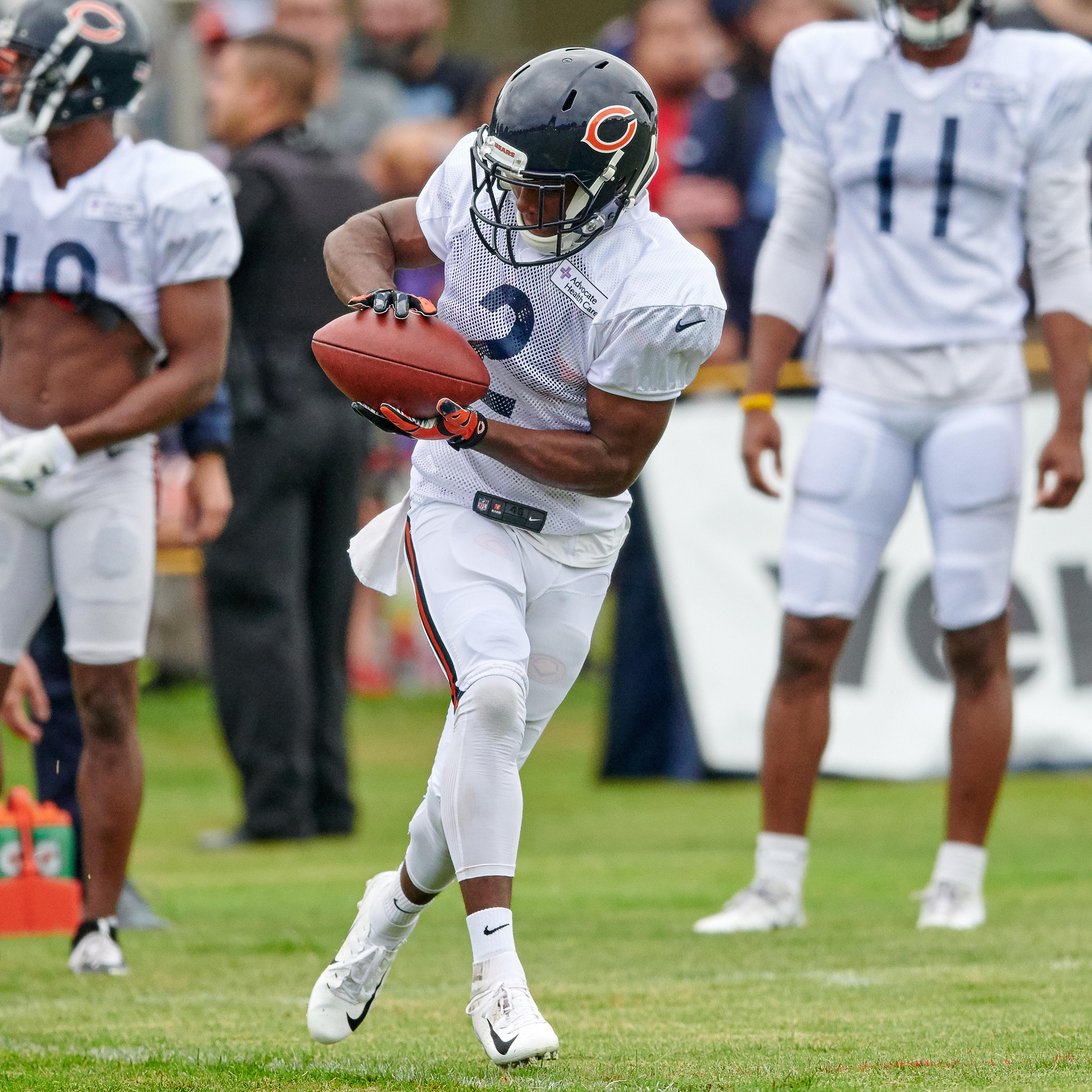 A football player catches the ball during practice