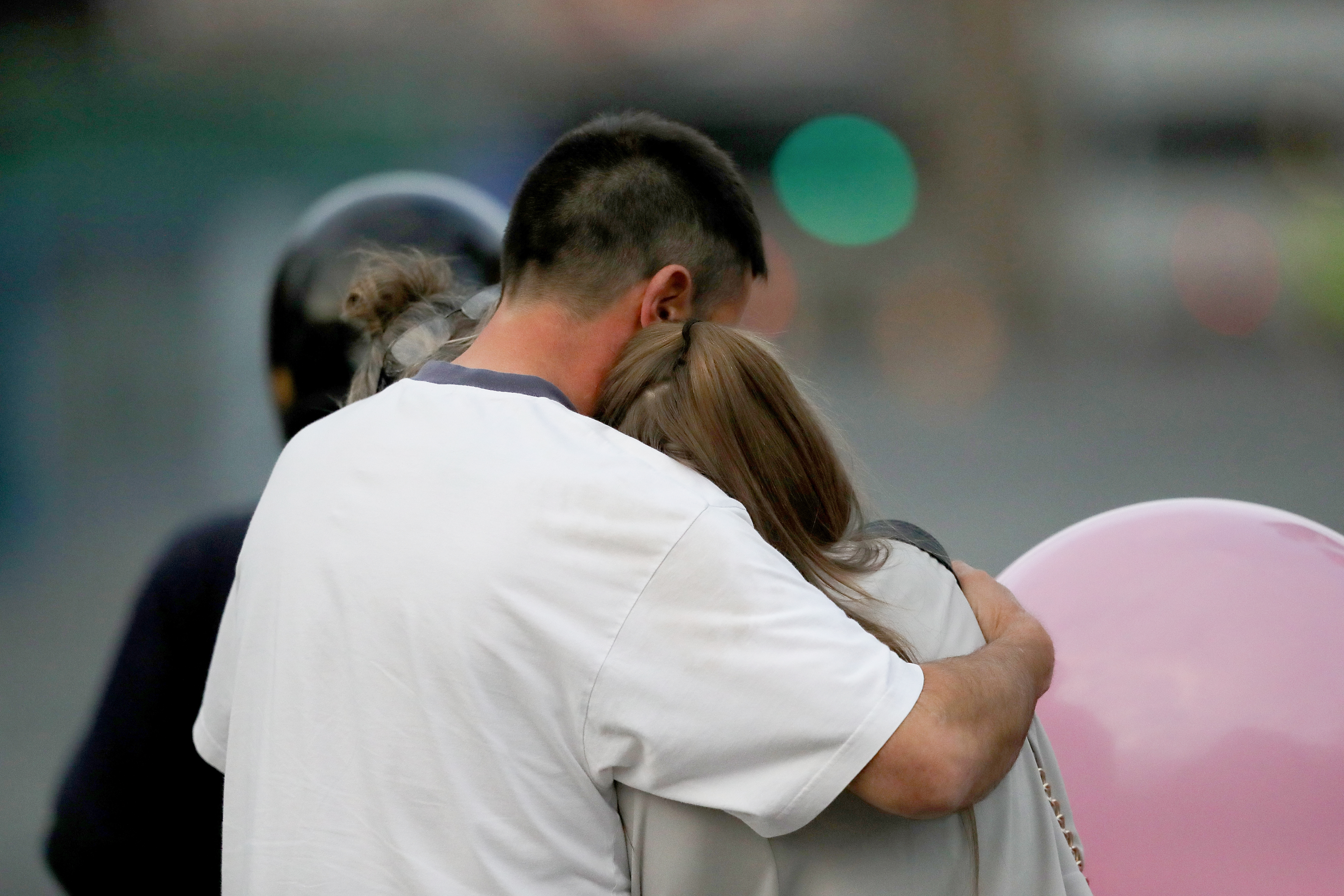 A man embraces a woman and a teenager as he collects them from the Park Inn Hotel where they were given refuge after last nights explosion at the Manchester Arena on May 23, 2017 in Manchester, England.