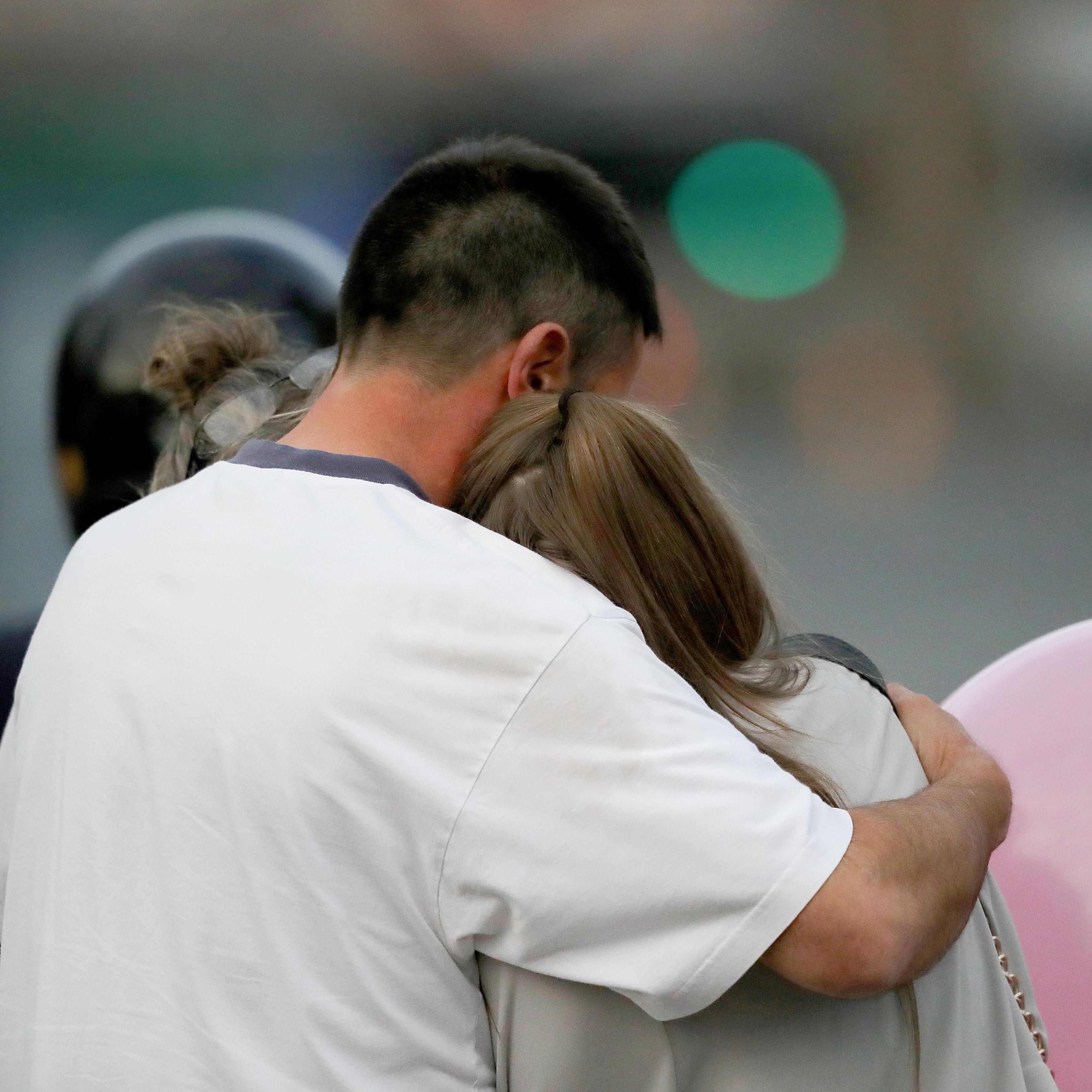 A man embraces a woman and a teenager as he collects them from the Park Inn Hotel where they were given refuge after last nights explosion at the Manchester Arena on May 23, 2017 in Manchester, England.