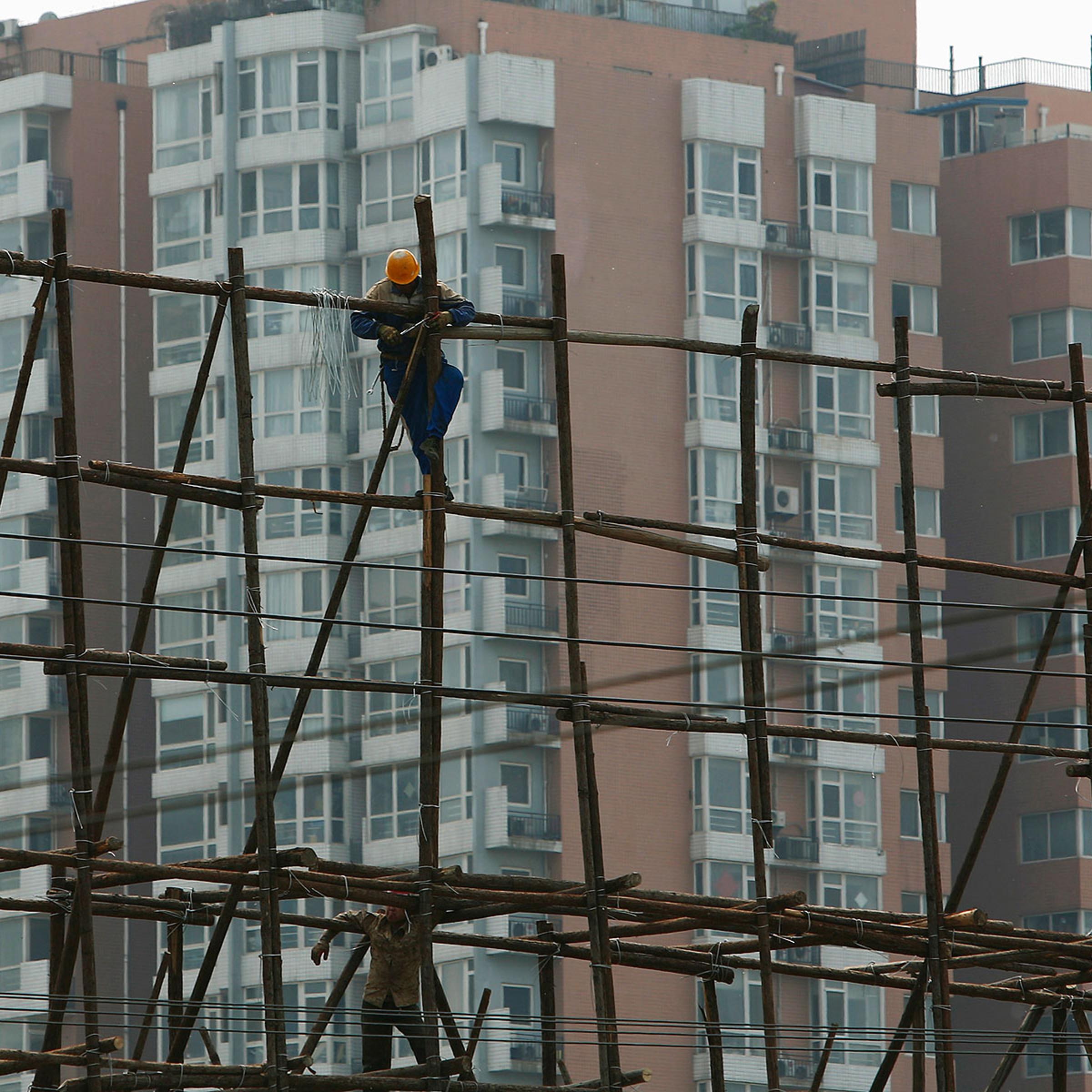 A laborer works on the scaffolding of a construction site for a new residential building in Beijing on May 8, 2014