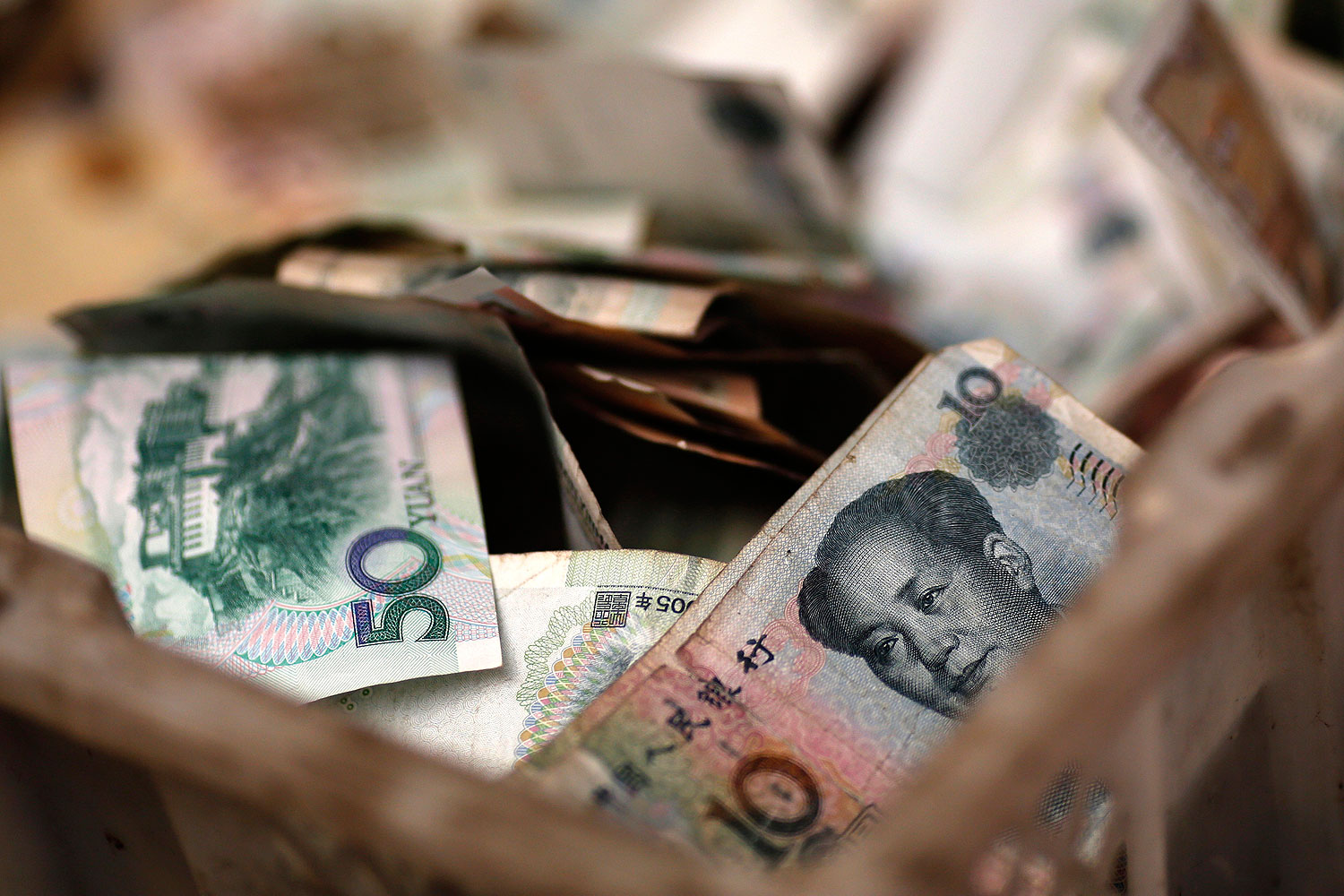 Chinese banknotes are seen at a vendor's cash box at a market in Beijing Feb. 14, 2014