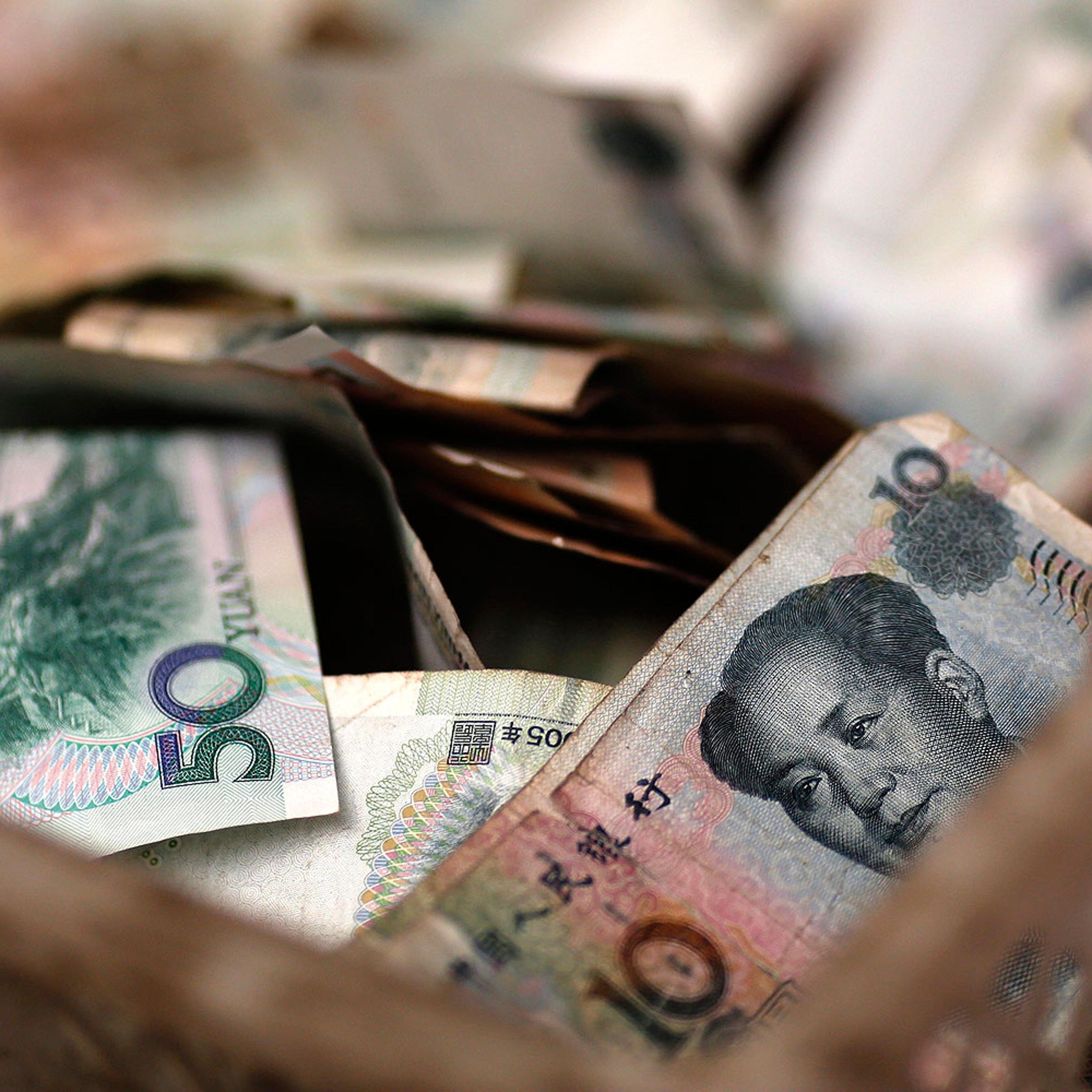 Chinese banknotes are seen at a vendor's cash box at a market in Beijing Feb. 14, 2014