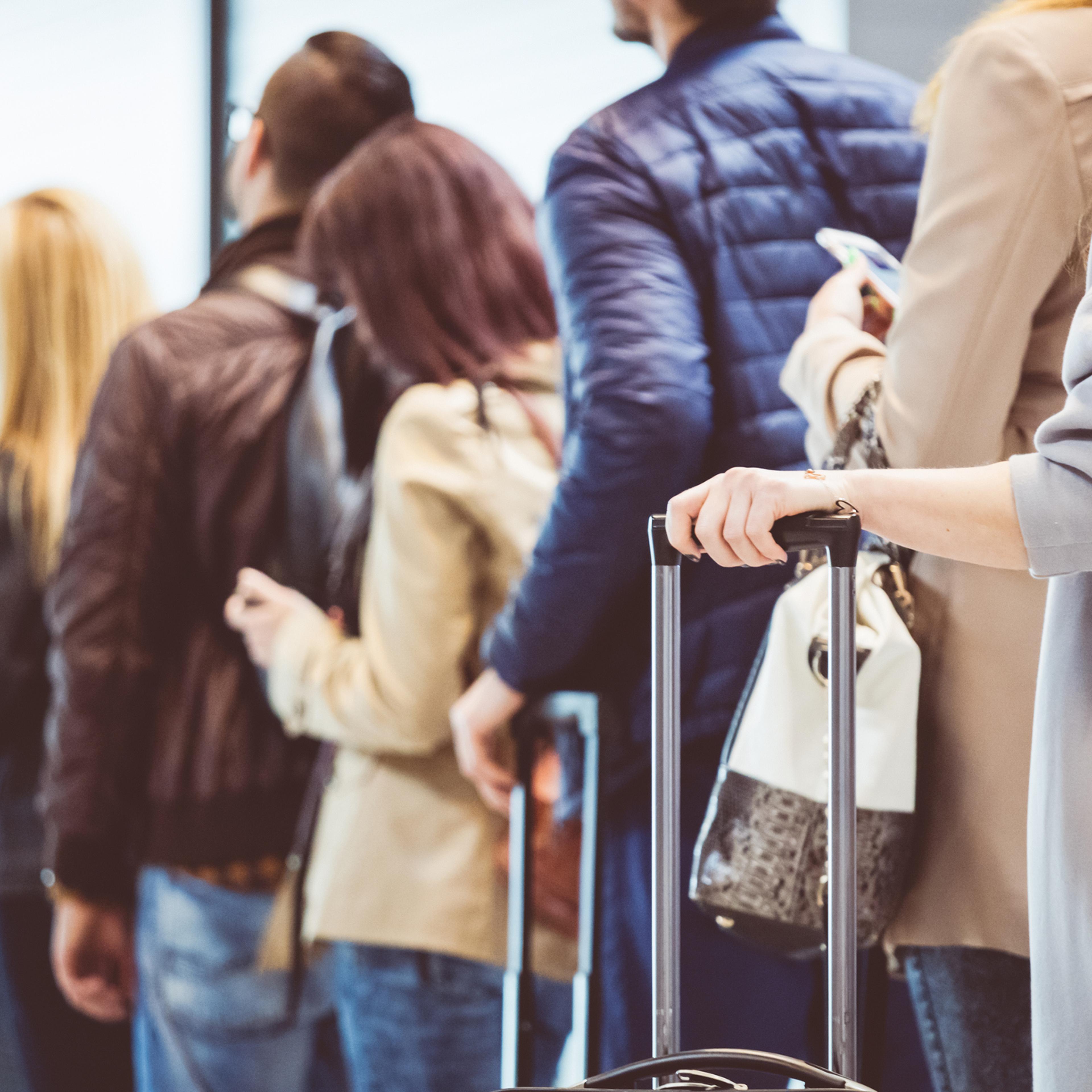 Group of people standing in queue at boarding gate