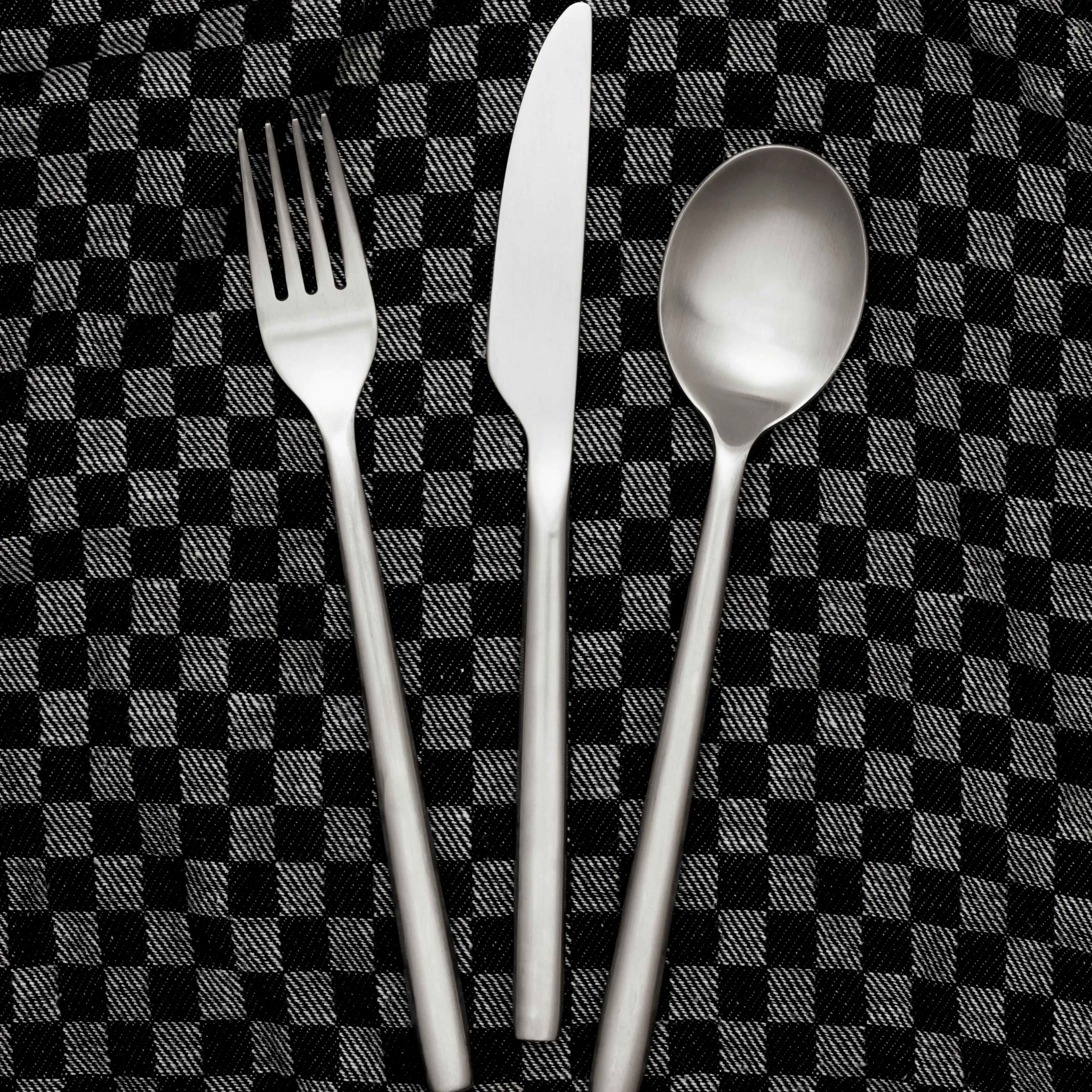 Fork, knife and spoon on dishcloth