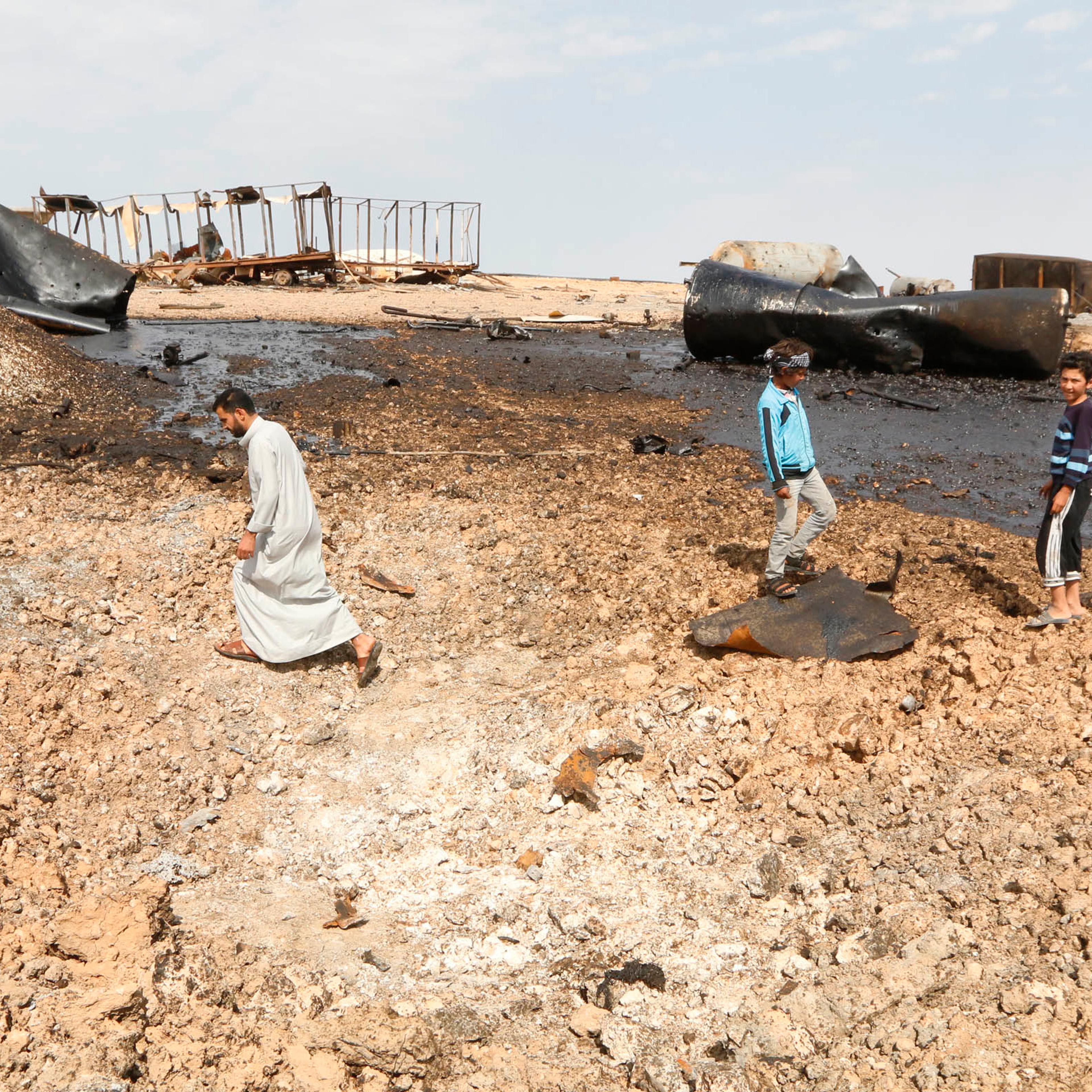 People inspect damage at an oil refinery that was targeted by what activists said were U.S.-led air strikes at al-Khaboura village, near the Syrian town of Tel Abyad of Raqqa governate
