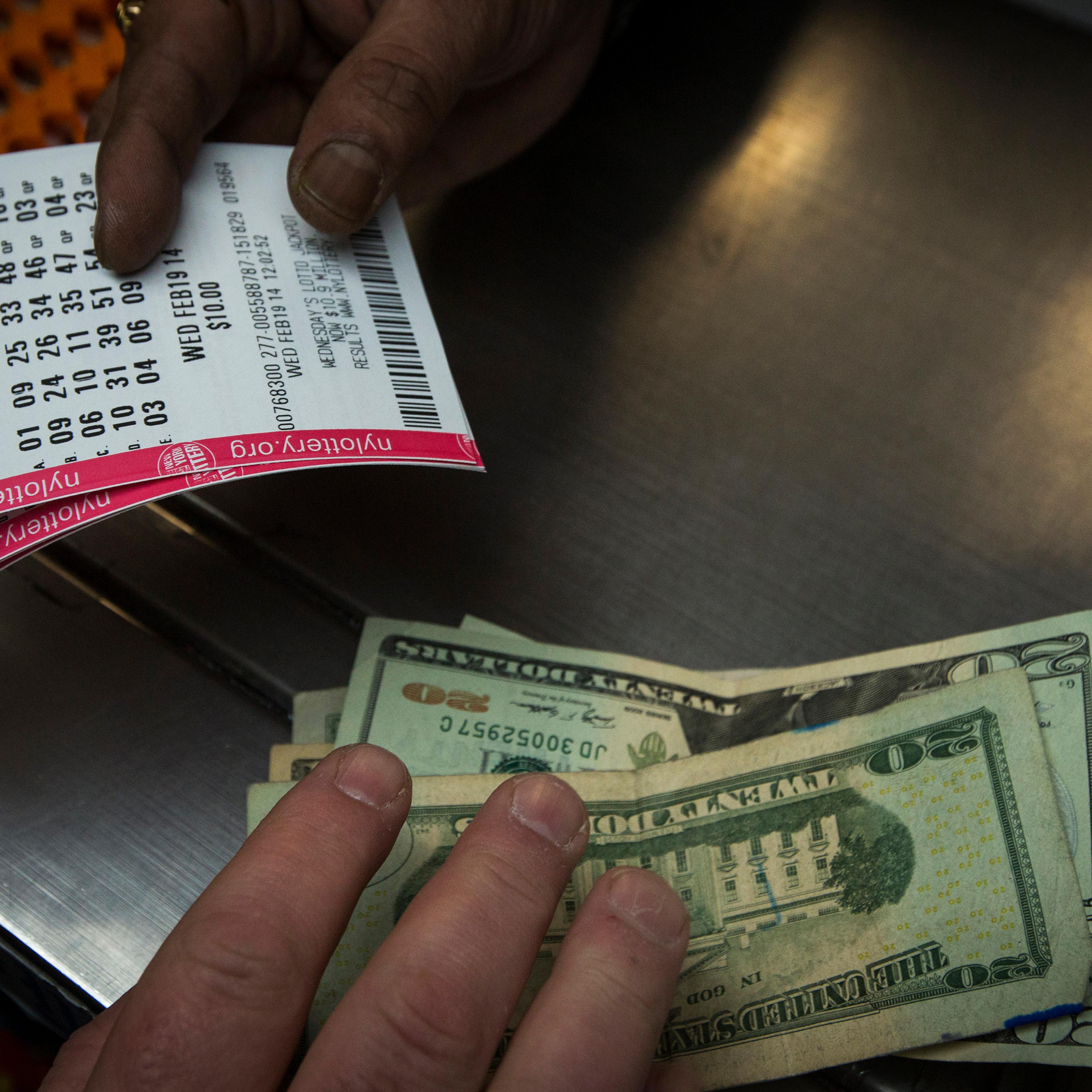 A man purchases New York State Lottery tickets for the $400 million Powerball lottery in New York's financial district