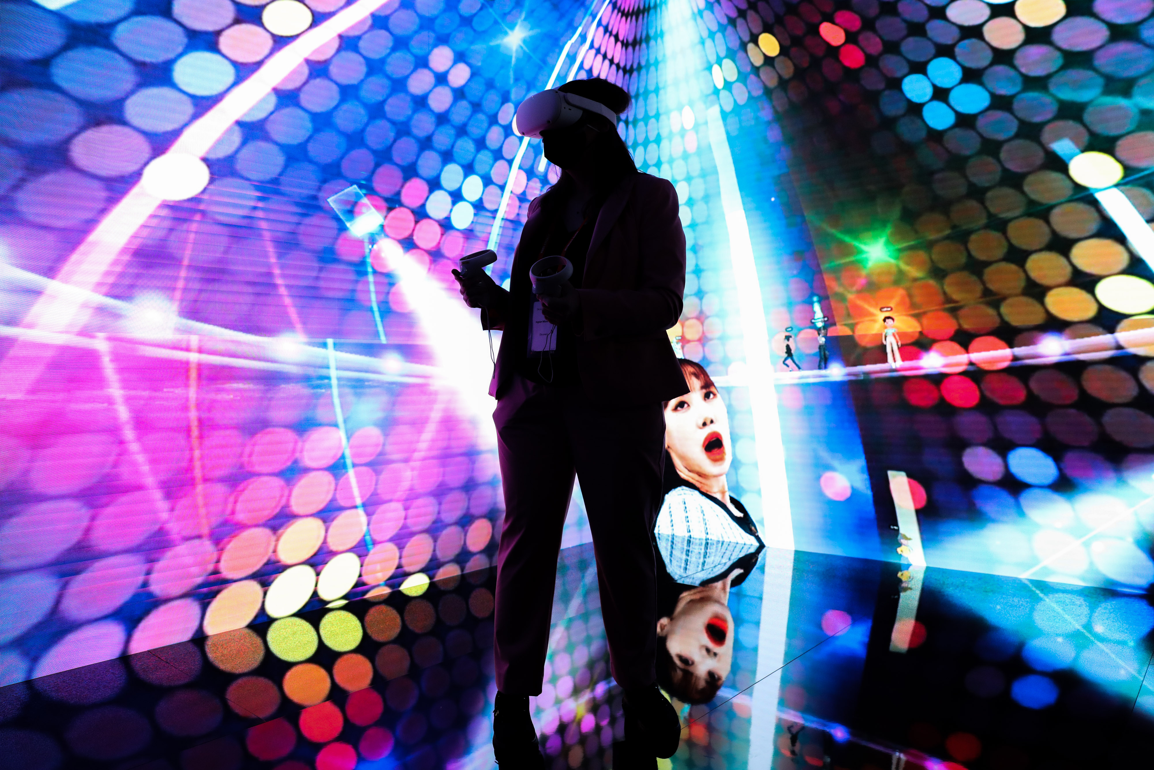 A woman wearing a virtual reality headset takes part in a metaverse concert experience at MWC Barcelona conference in Barcelona, Spain on Feb. 28, 2022.