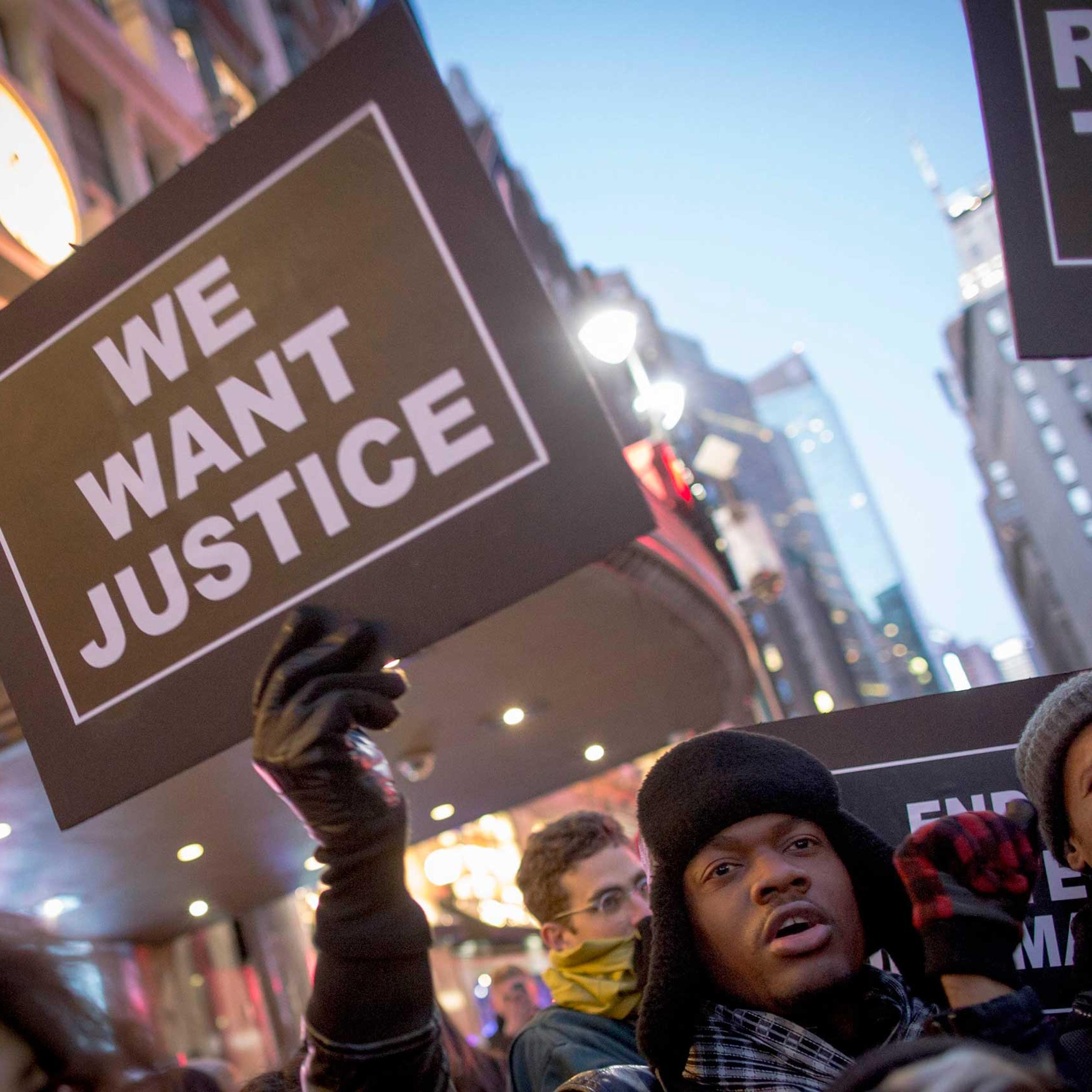 A protester holds up a sign while demonstrating outside of Macy's in Herald Square during the Black Friday shopping day in New York