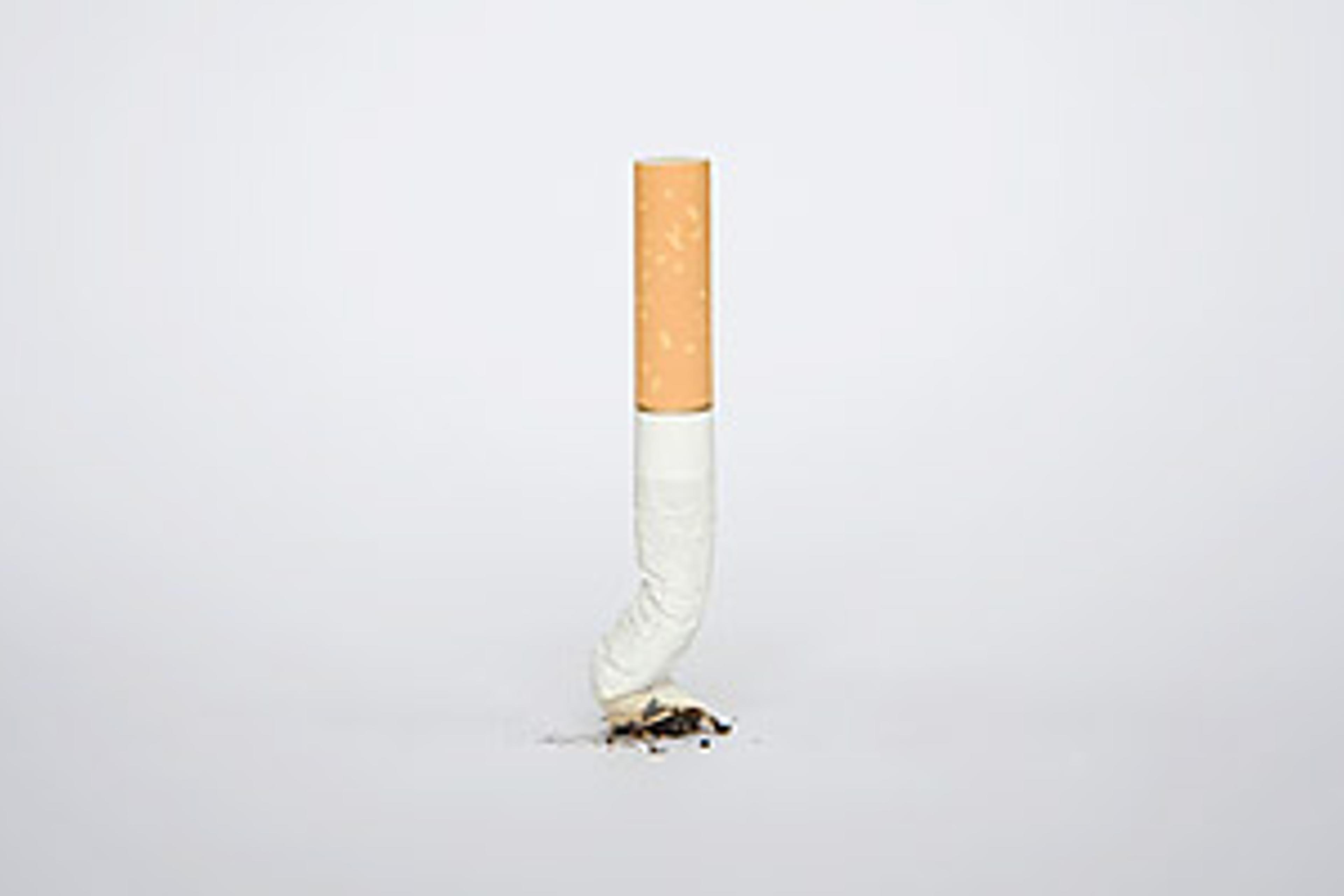 enjoy smoking cigarettes Young white brunette girl enjoying smoking a cigarette outside. Trees in the background, leaning back, head tilted up. Stock Photo