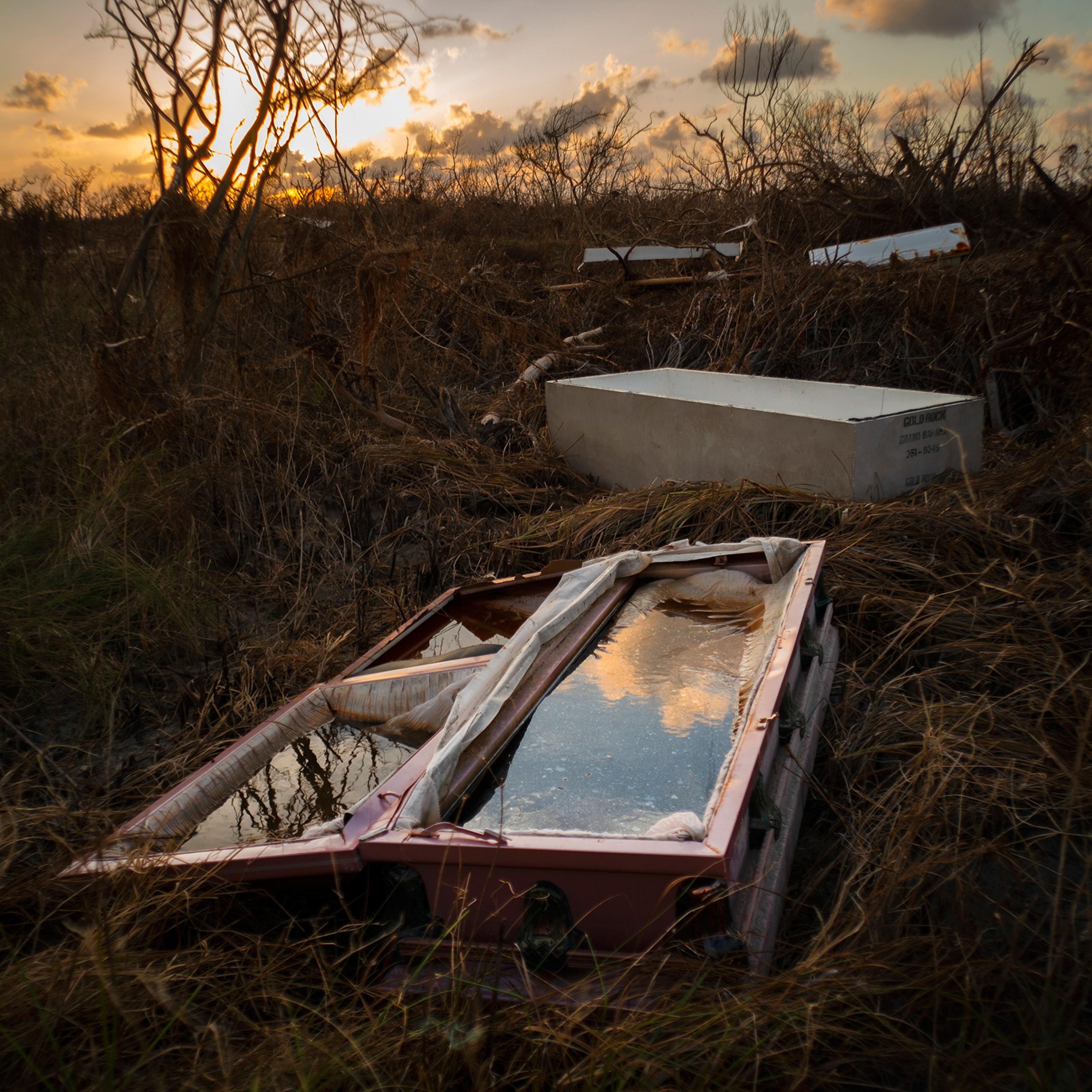 A water-filled coffin lays exposed to the elements in the aftermath of Hurricane Dorian, at the cemetery in Mclean's Town, Grand Bahama, Bahamas, Wednesday Sept. 11, 2019.