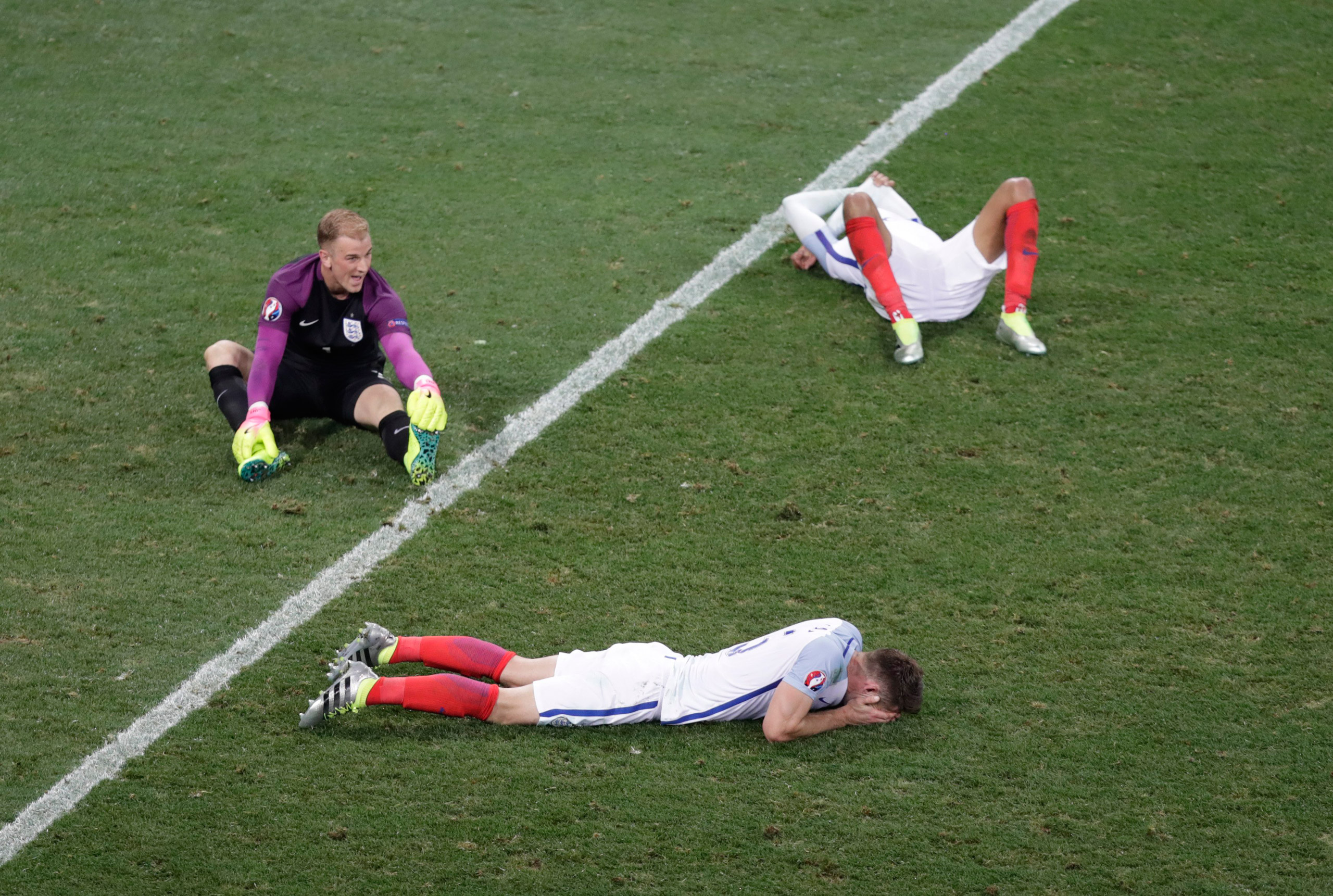 England goalkeeper Joe Hart, left, and two others player lie on the pitch at the end of the Euro 2016 round of 16 soccer match between England and Iceland, at the Allianz Riviera stadium in Nice, France, Monday, June 27, 2016. Iceland won 2-1. (AP Photo/