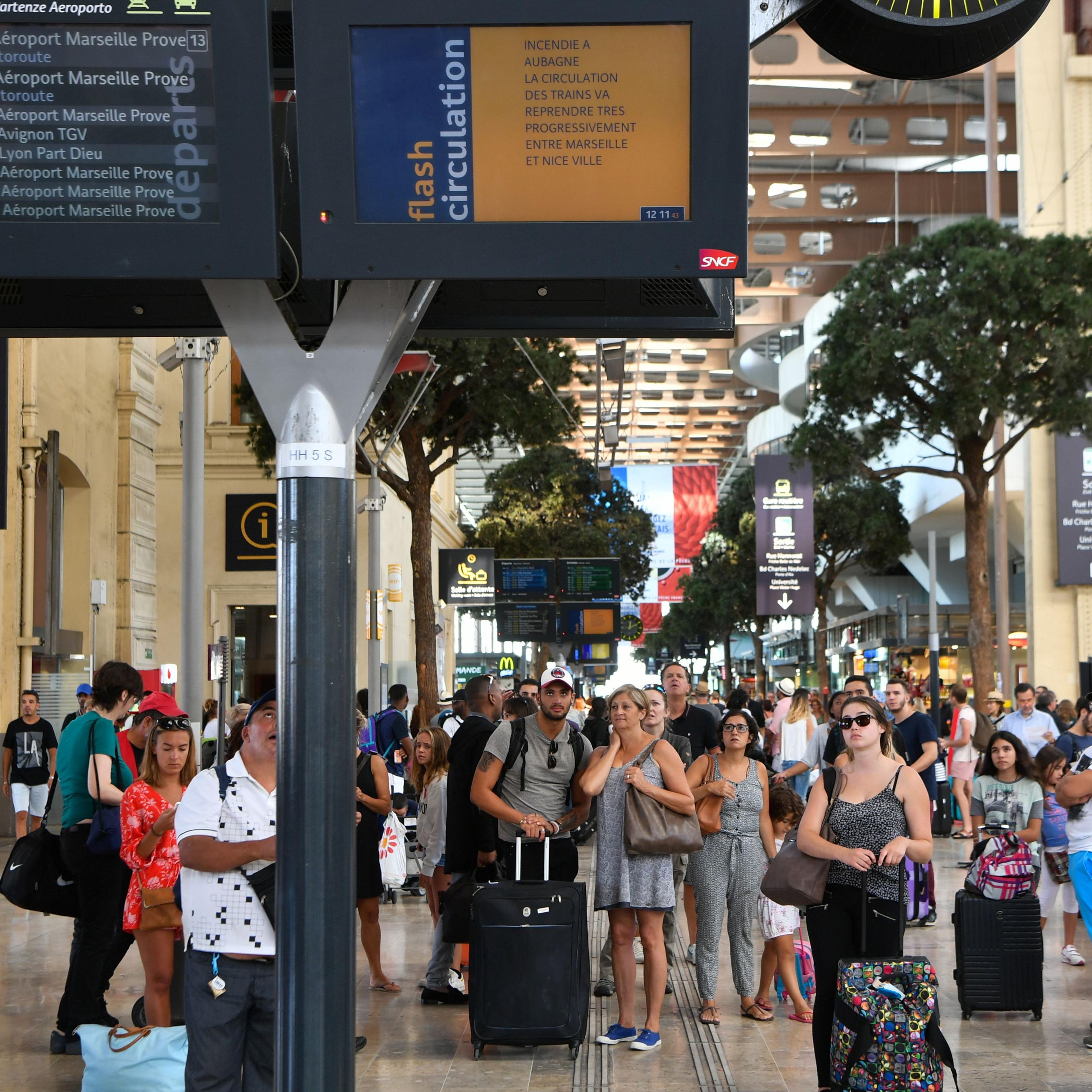 Passengers look at information monitors as they wait for their trains at The Saint-Charles Station in Marseille on Aug. 20, 2017.