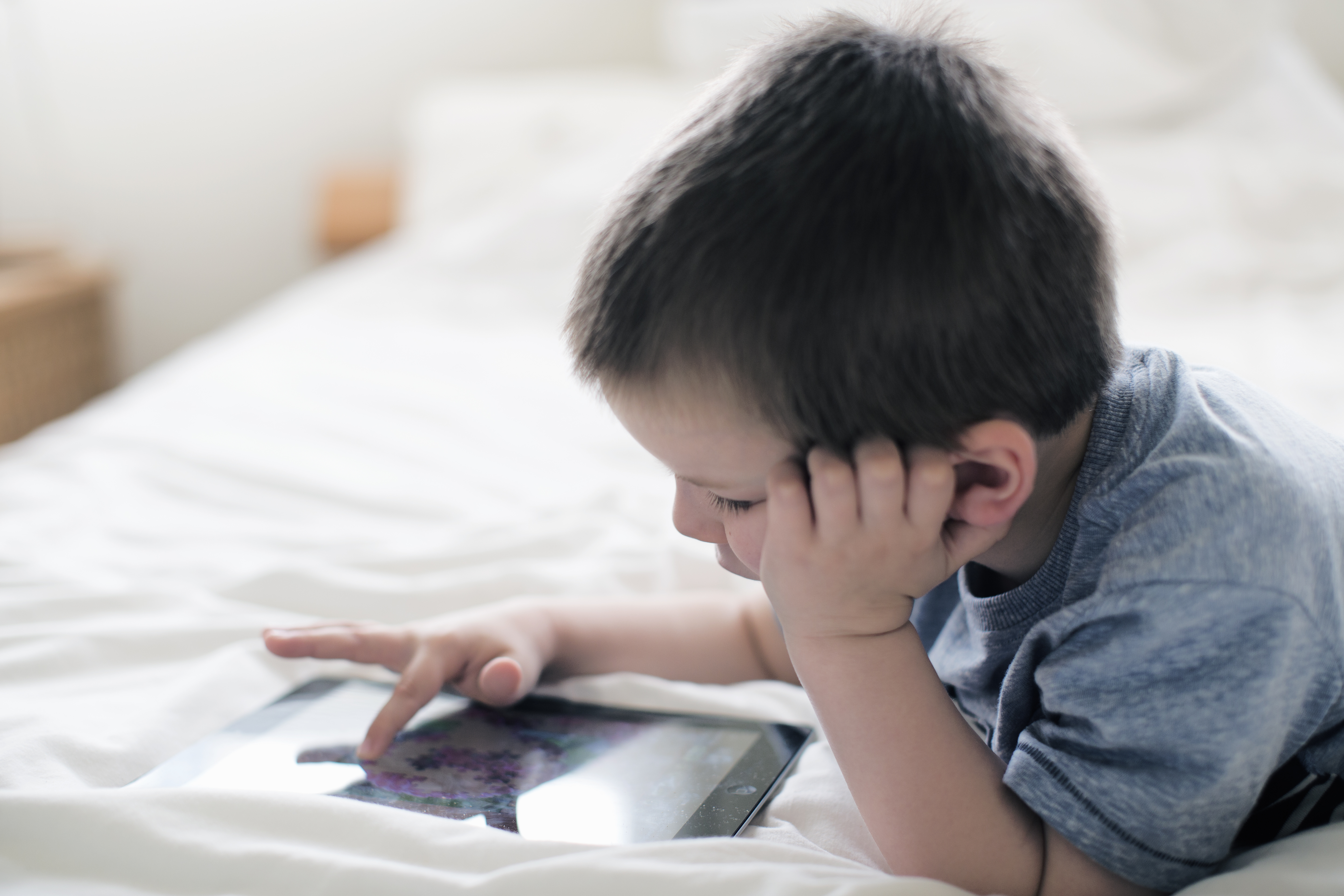 boy-using-tablet-bed