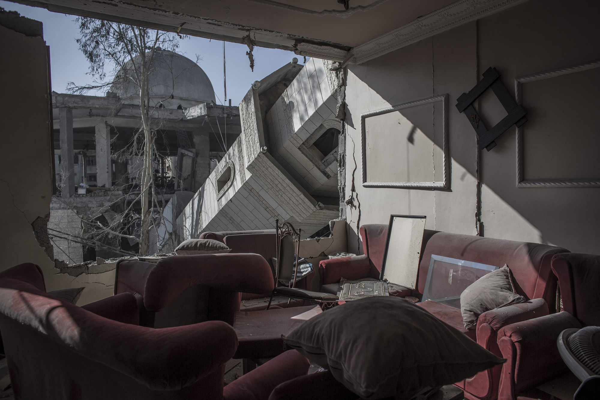The collapsed minaret of mosque seen from the destroyed living room of a Palestinian family in a building across the street in Gaza City, Gaza Strip, July 30, 2014.