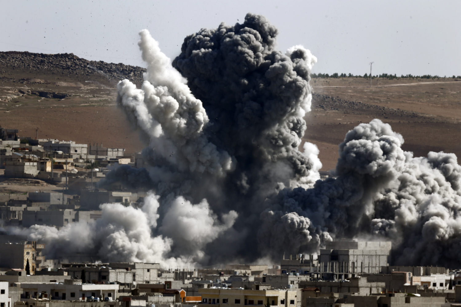 Smoke and dust rise over Syrian town of Kobani after an airstrike, as seen from the Mursitpinar crossing on the Turkish-Syrian border in the southeastern town of Suruc