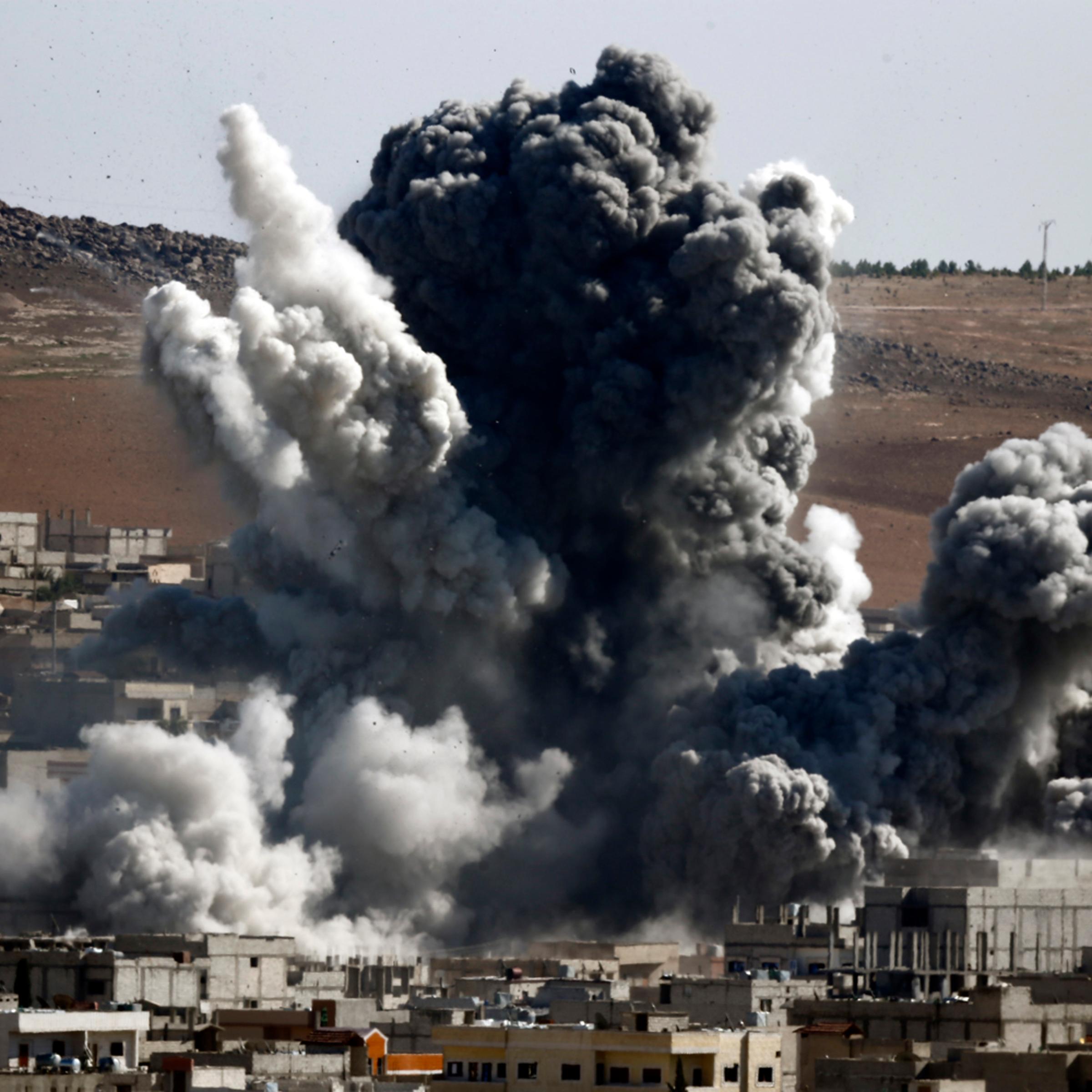 Smoke and dust rise over Syrian town of Kobani after an airstrike, as seen from the Mursitpinar crossing on the Turkish-Syrian border in the southeastern town of Suruc