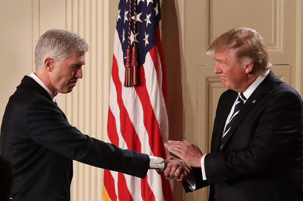 President Donald Trump (R) shakes hands with Judge Neil Gorsuch after nominating him to the Supreme Court.