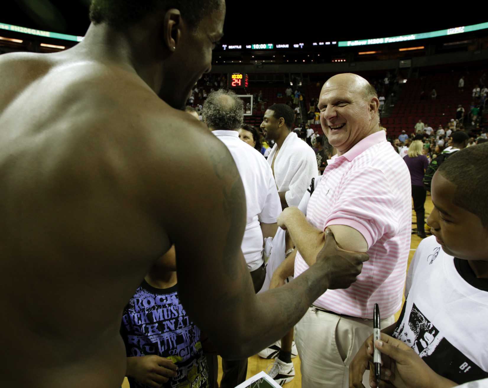 Microsoft Corp. CEO Steve Ballmer, right, reacts as Martell Webster, left, of the NBA's Minnesota Timberwolves, checks the size of Ballmer's bicep, following a charity basketball game, Saturday, July 23, 2011, in Seattle. 