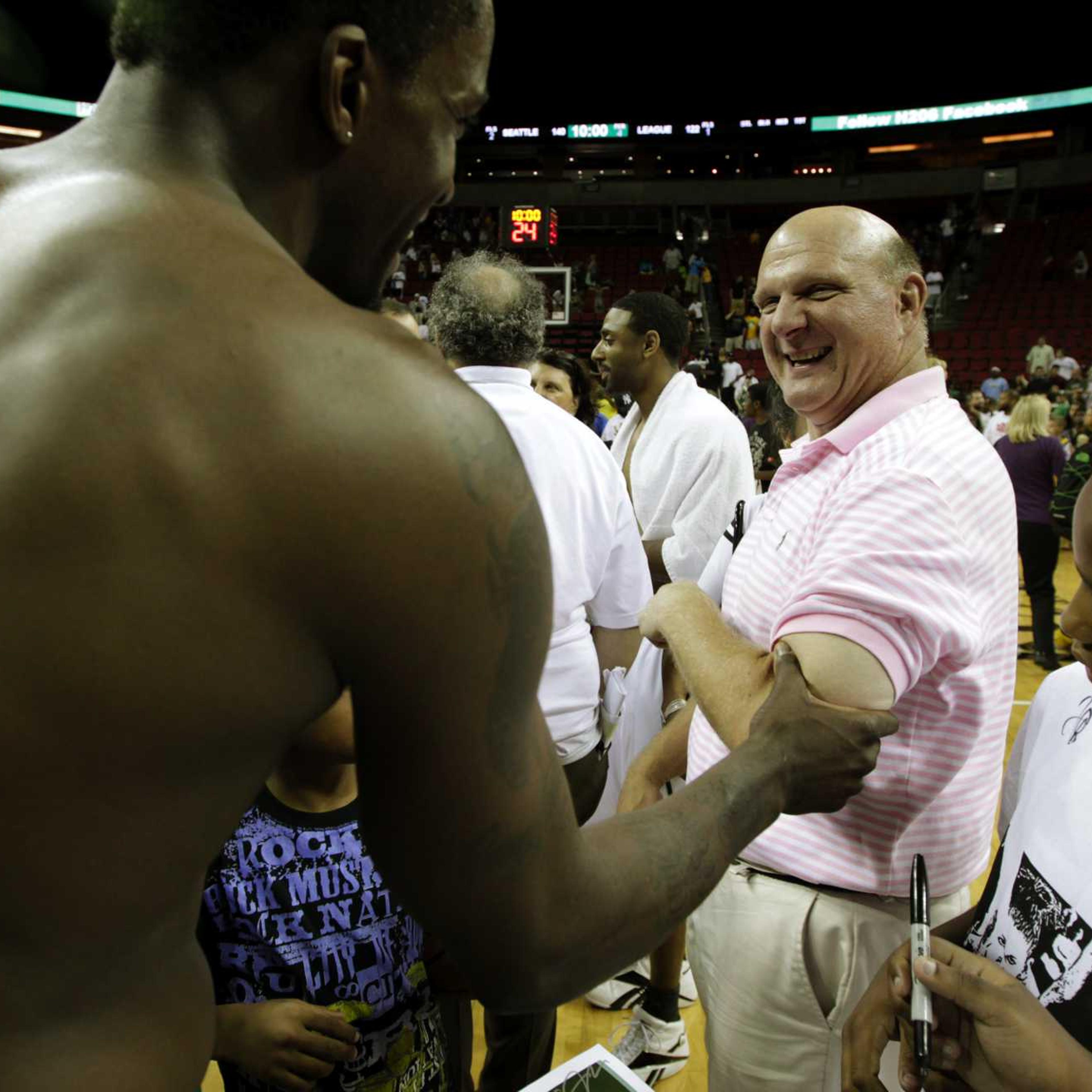 Microsoft Corp. CEO Steve Ballmer, right, reacts as Martell Webster, left, of the NBA's Minnesota Timberwolves, checks the size of Ballmer's bicep, following a charity basketball game, Saturday, July 23, 2011, in Seattle.