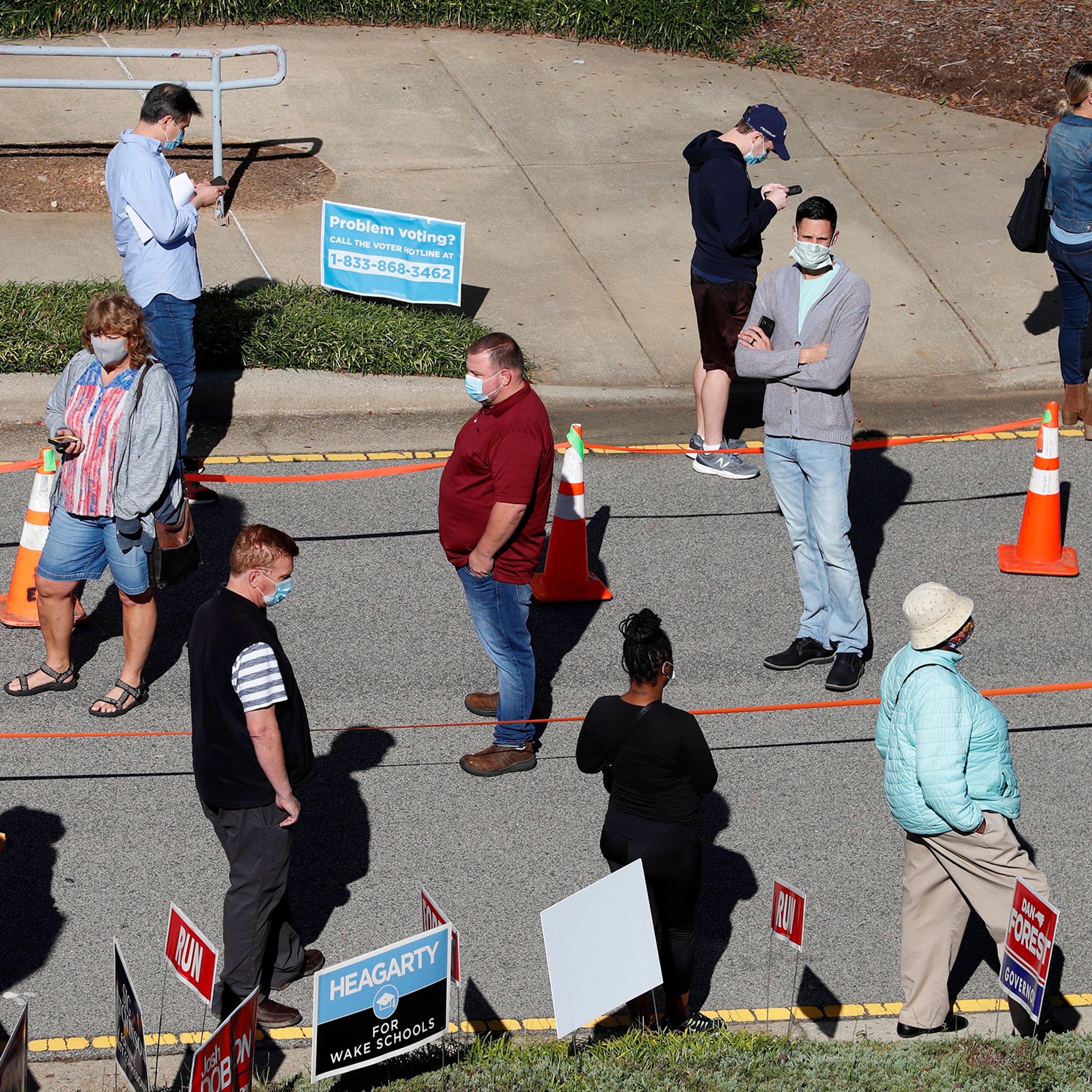 Voters wait in line outside the Herbert C. Young Community Center in Cary, N.C. on the first day of early voting on, Oct. 15, 2020.