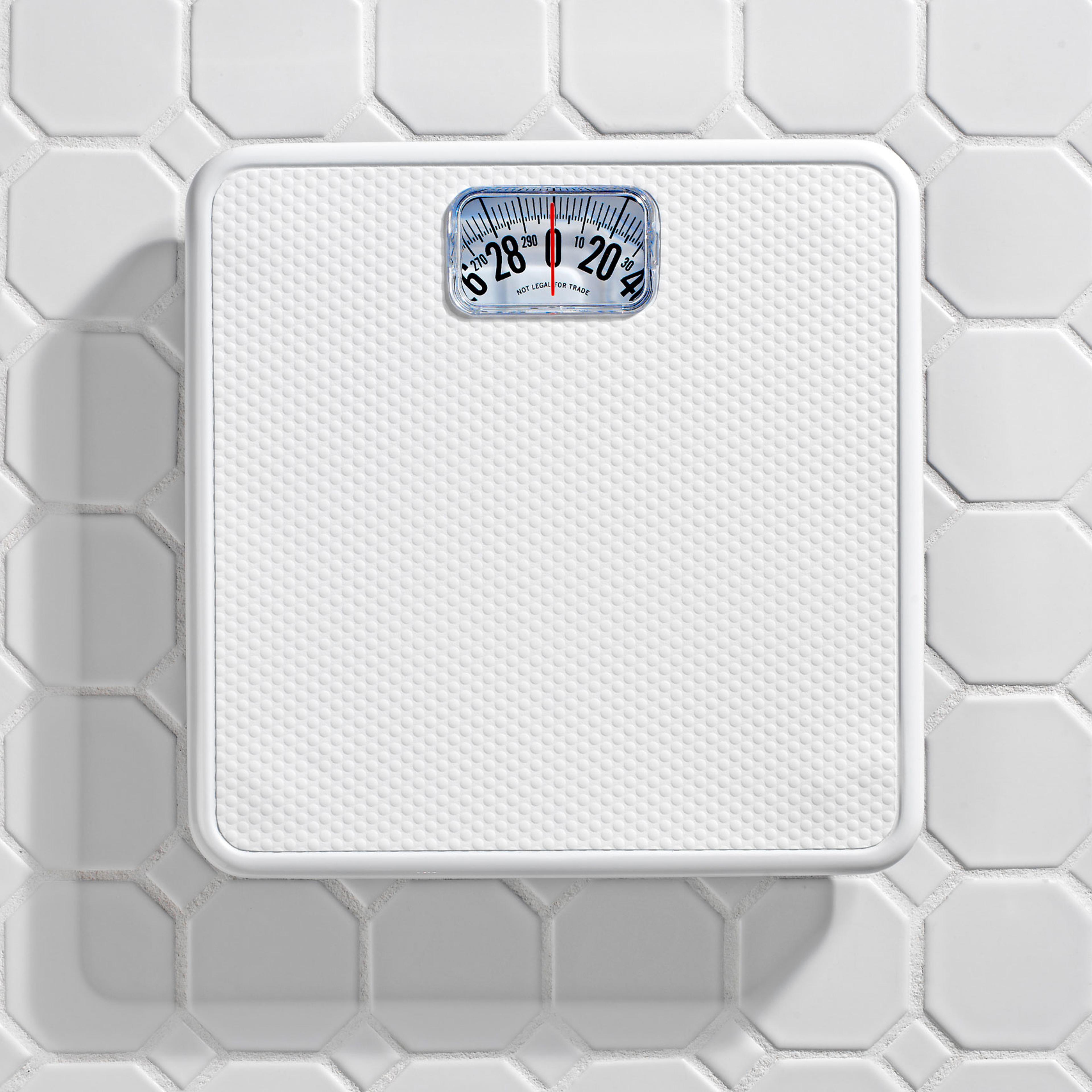 Bathroom scale on white tile floor.