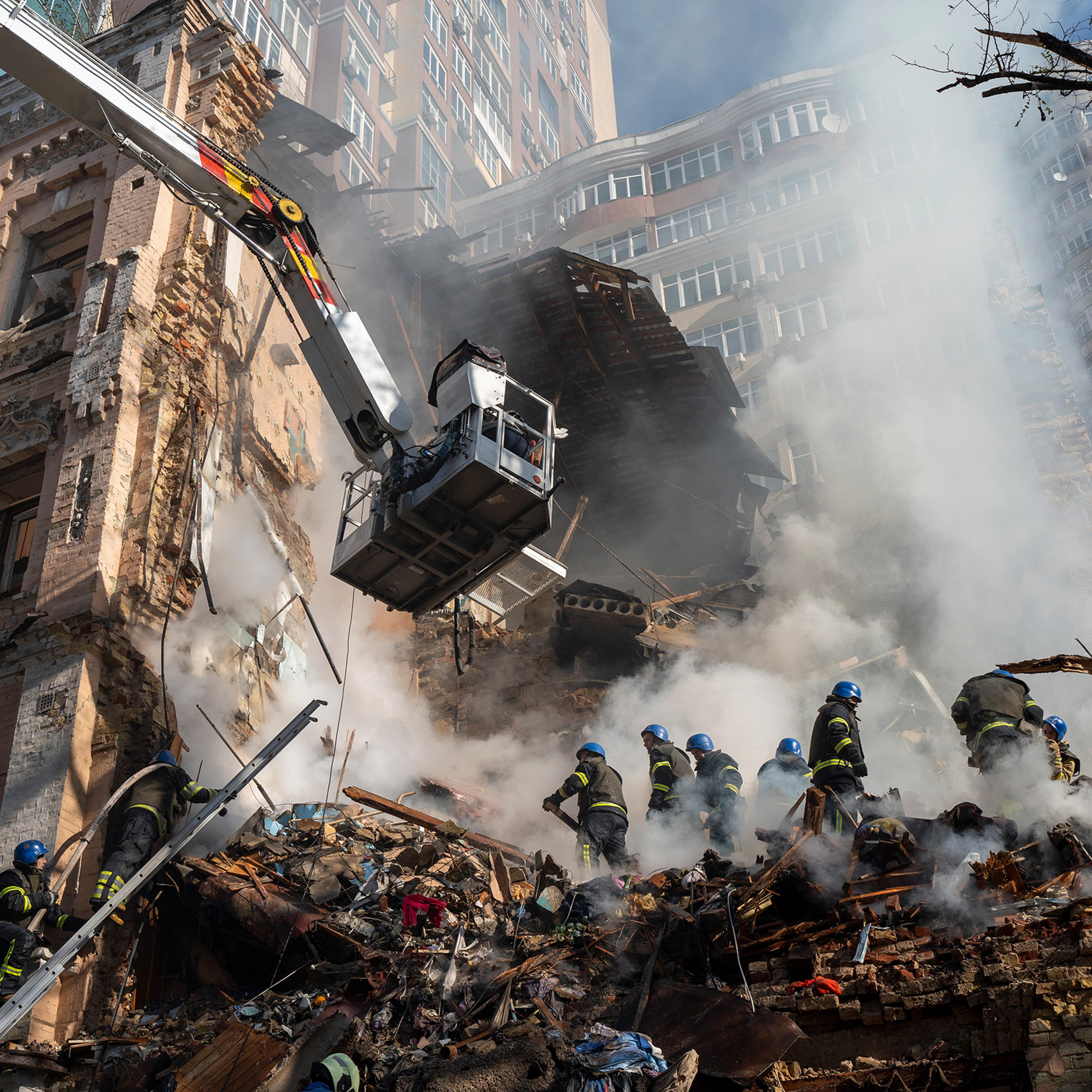 Firefighters work after a drone attack on buildings in Kyiv, Ukraine on Oct. 17. Waves of explosive-laden suicide drones struck Ukraine's capital as families were preparing to start their week early Monday, the blasts echoing across Kyiv, setting buildings ablaze and sending people scurrying to shelters.