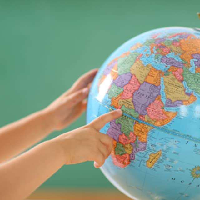 Child looks at school globe