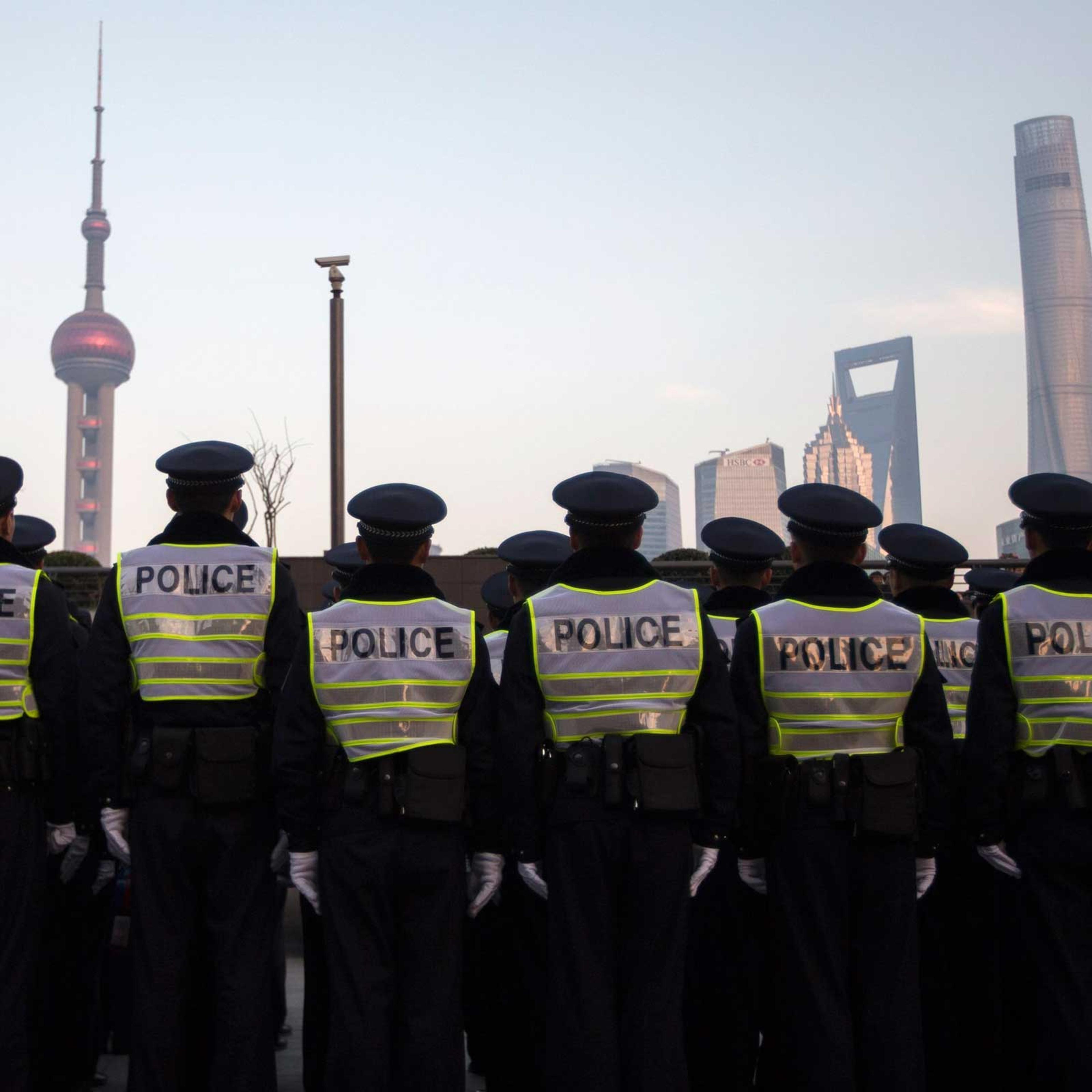 Policemen stand in formation as they guard on the bund where people were killed in a stampede incident during a new year's celebration, in Shanghai
