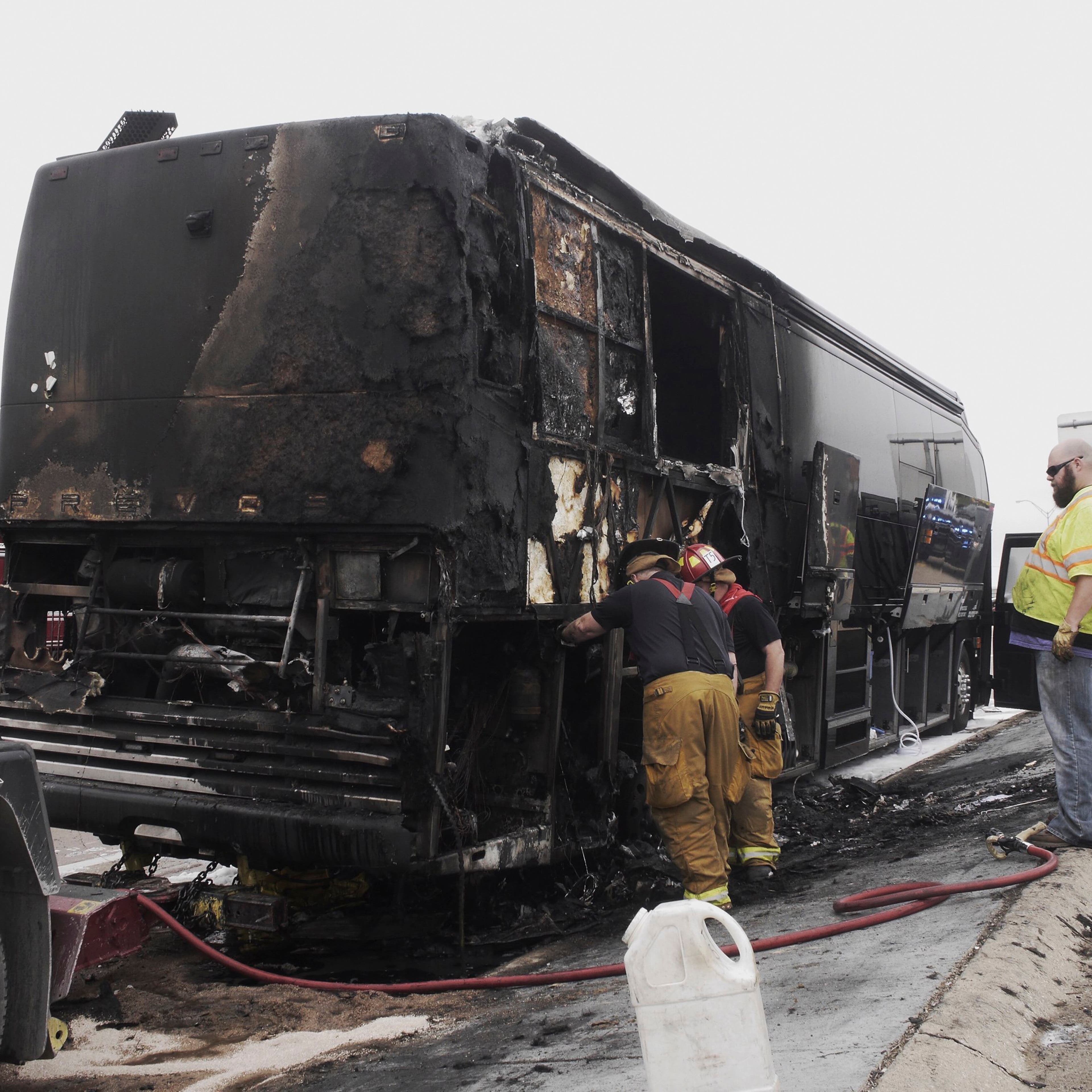 Firemen look at the damage after a fire on Lady Antebellum's bus on eastbound I-30 in Garland, Texas