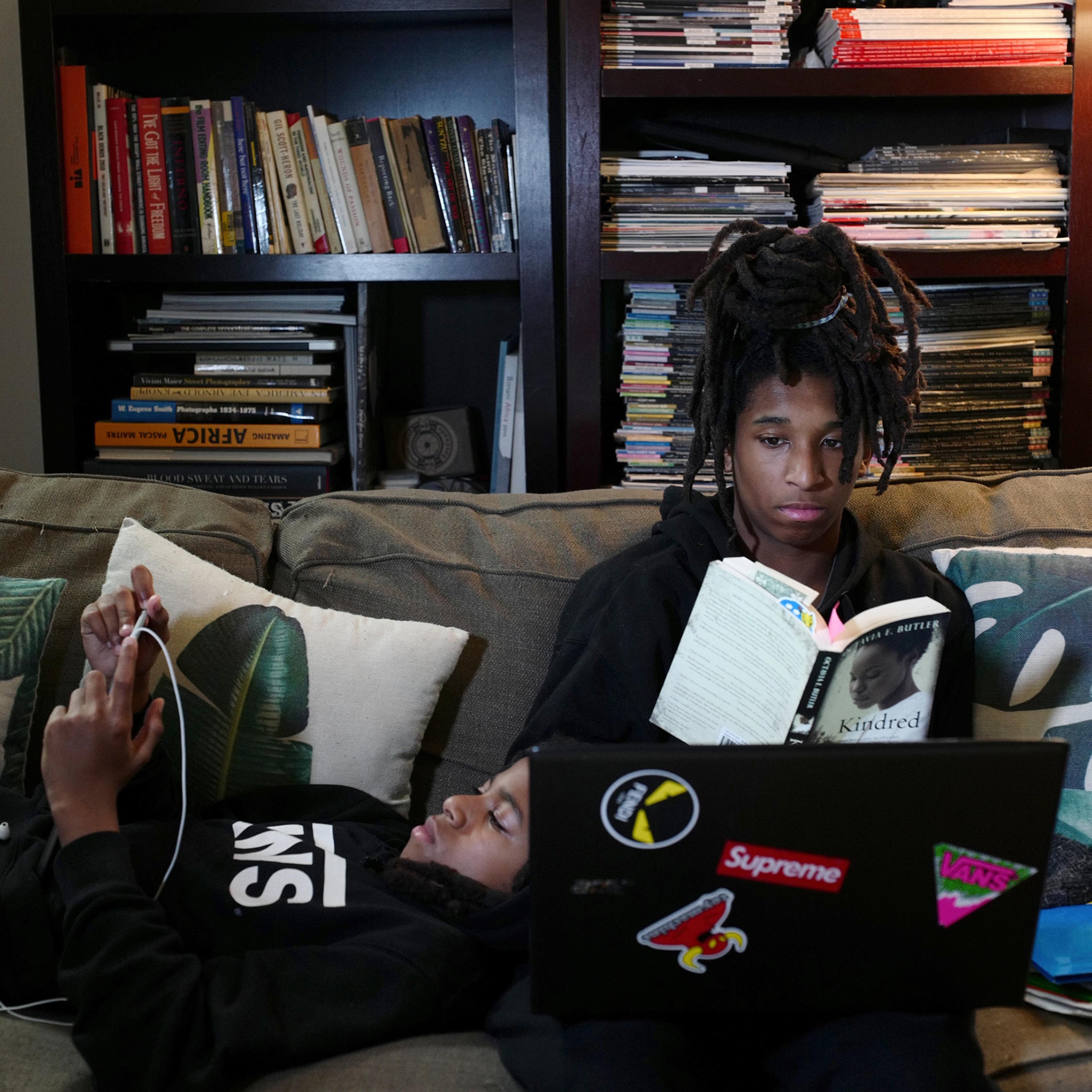 Mosijah Roye, 15, right, and Iyeoshujah, 11, the photographer’s sons, follow online classes in New York on March 23 on their home devices