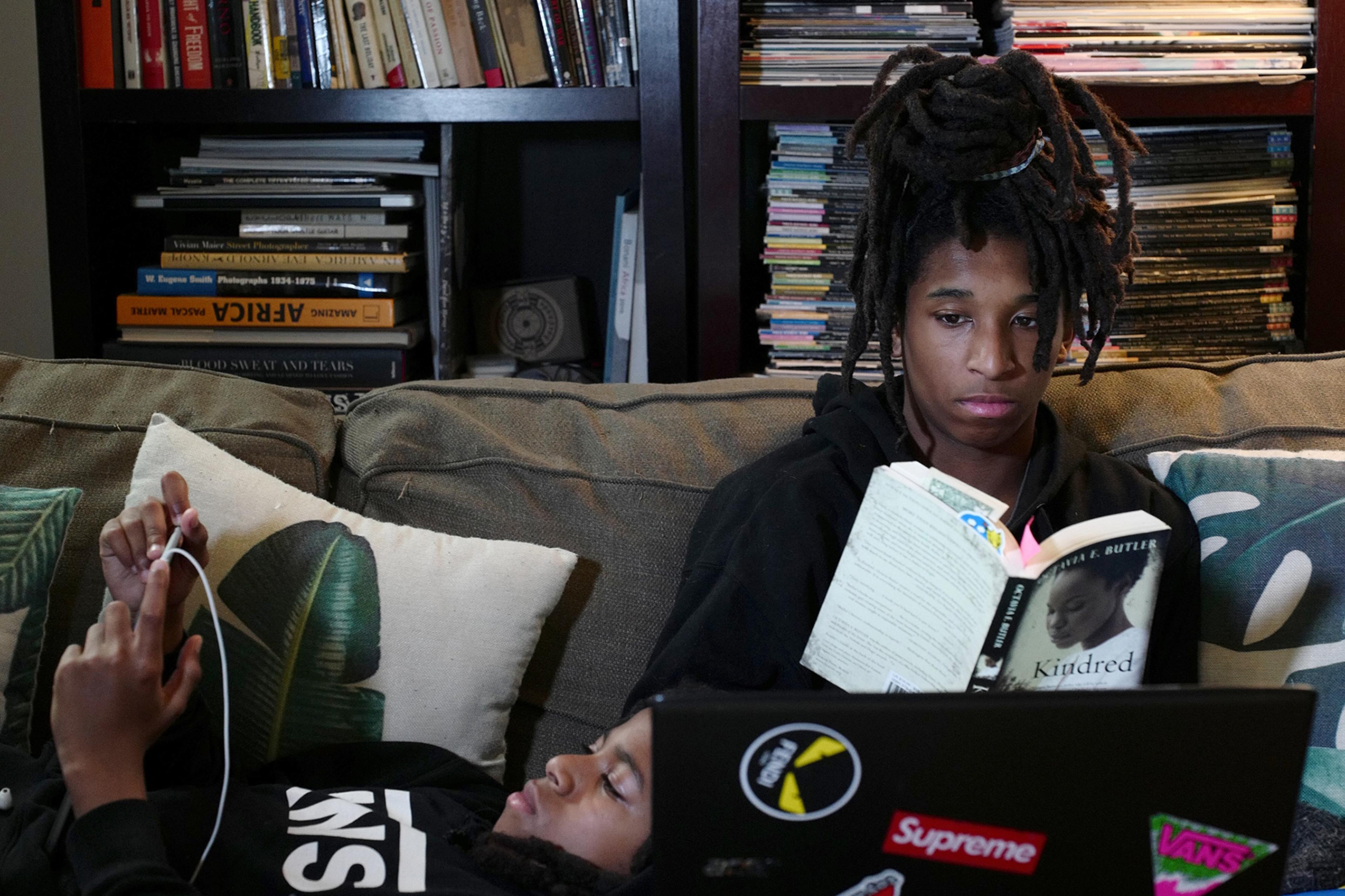 Mosijah Roye, 15, right, and Iyeoshujah, 11, the photographer’s sons, follow online classes in New York on March 23 on their home devices