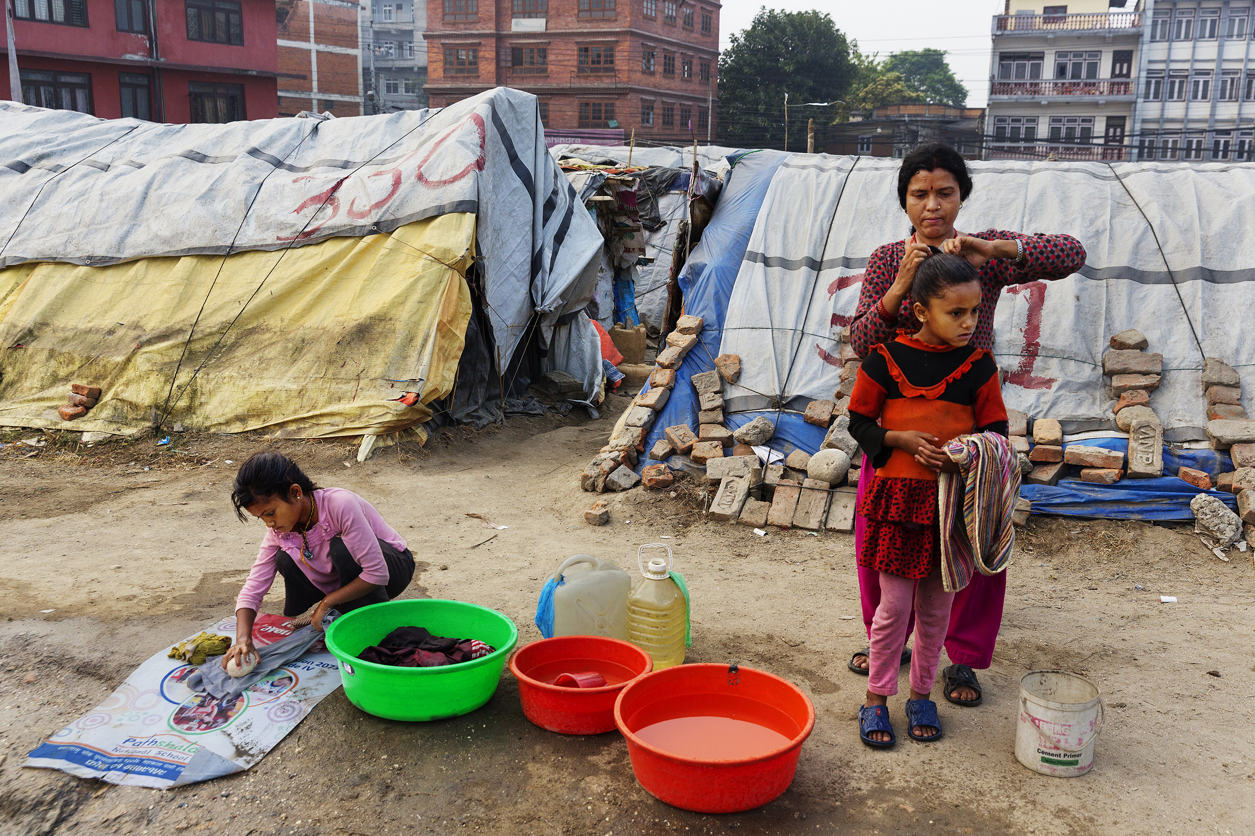 A woman and children at a squalid tent encampment in central Kathmandu, Nepal, nearly a year after the devastating 2015 earthquakes, March 31, 2016.