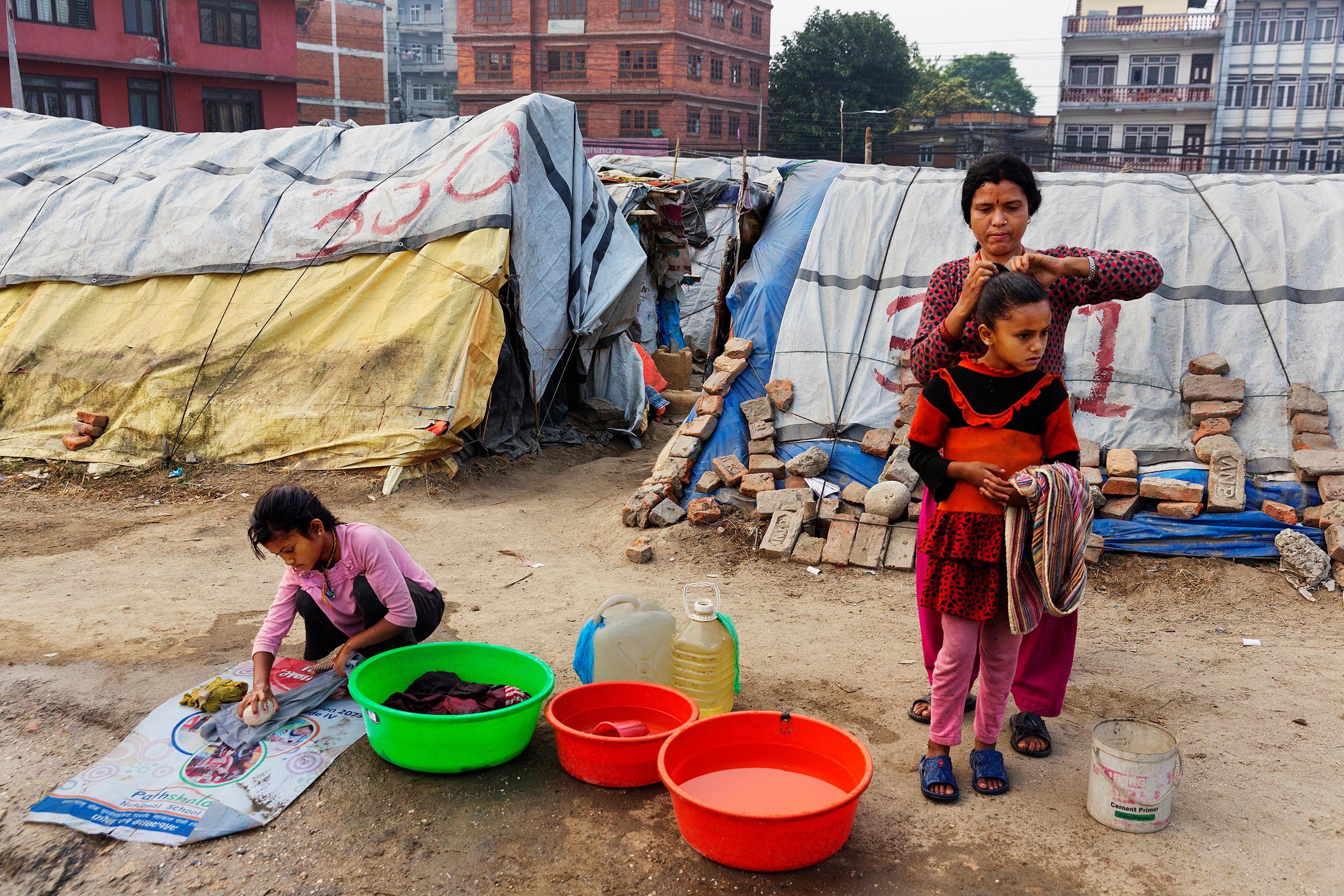 A woman and children at a squalid tent encampment in central Kathmandu, Nepal, nearly a year after the devastating 2015 earthquakes, March 31, 2016.