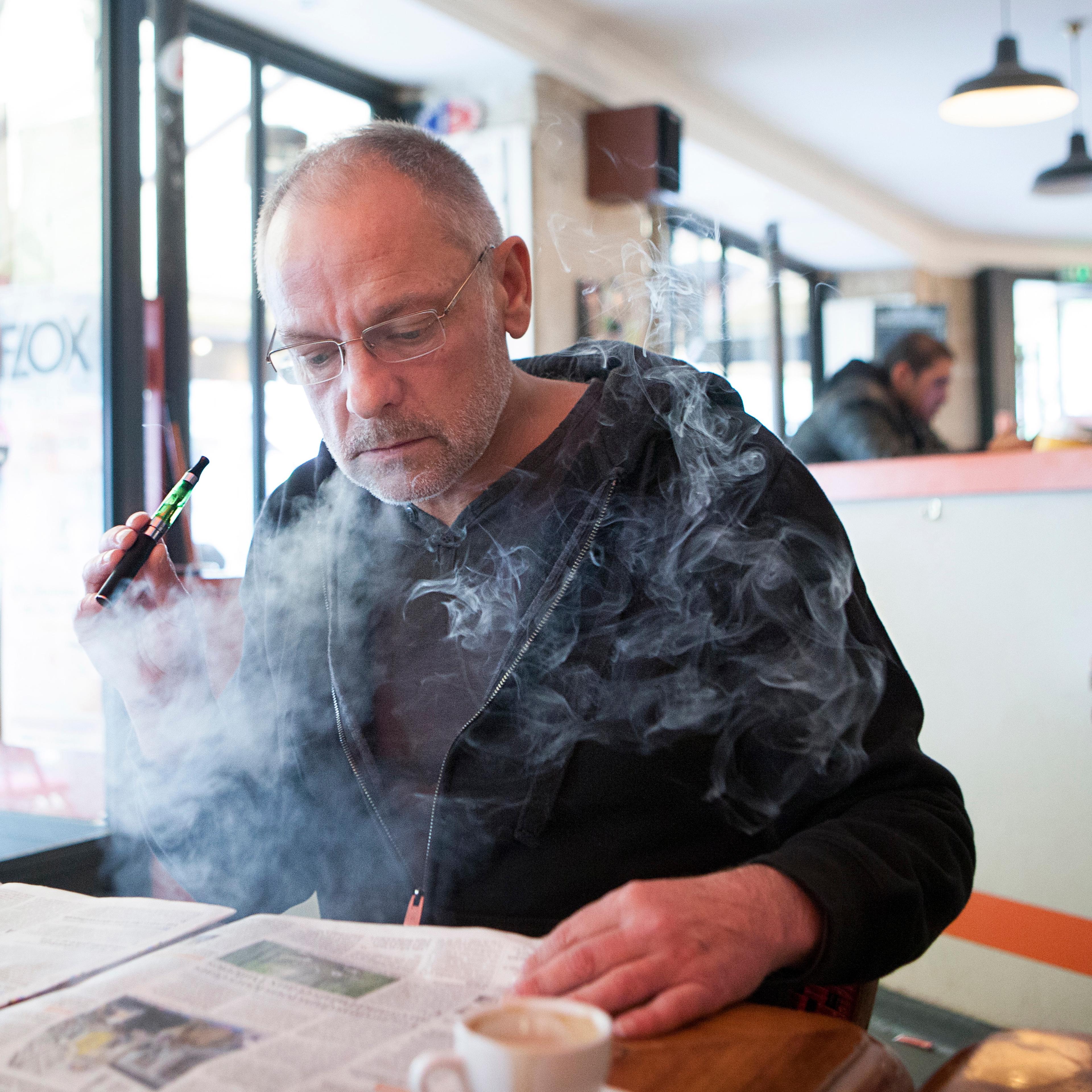 Man with an electronic cigarette in a public place.