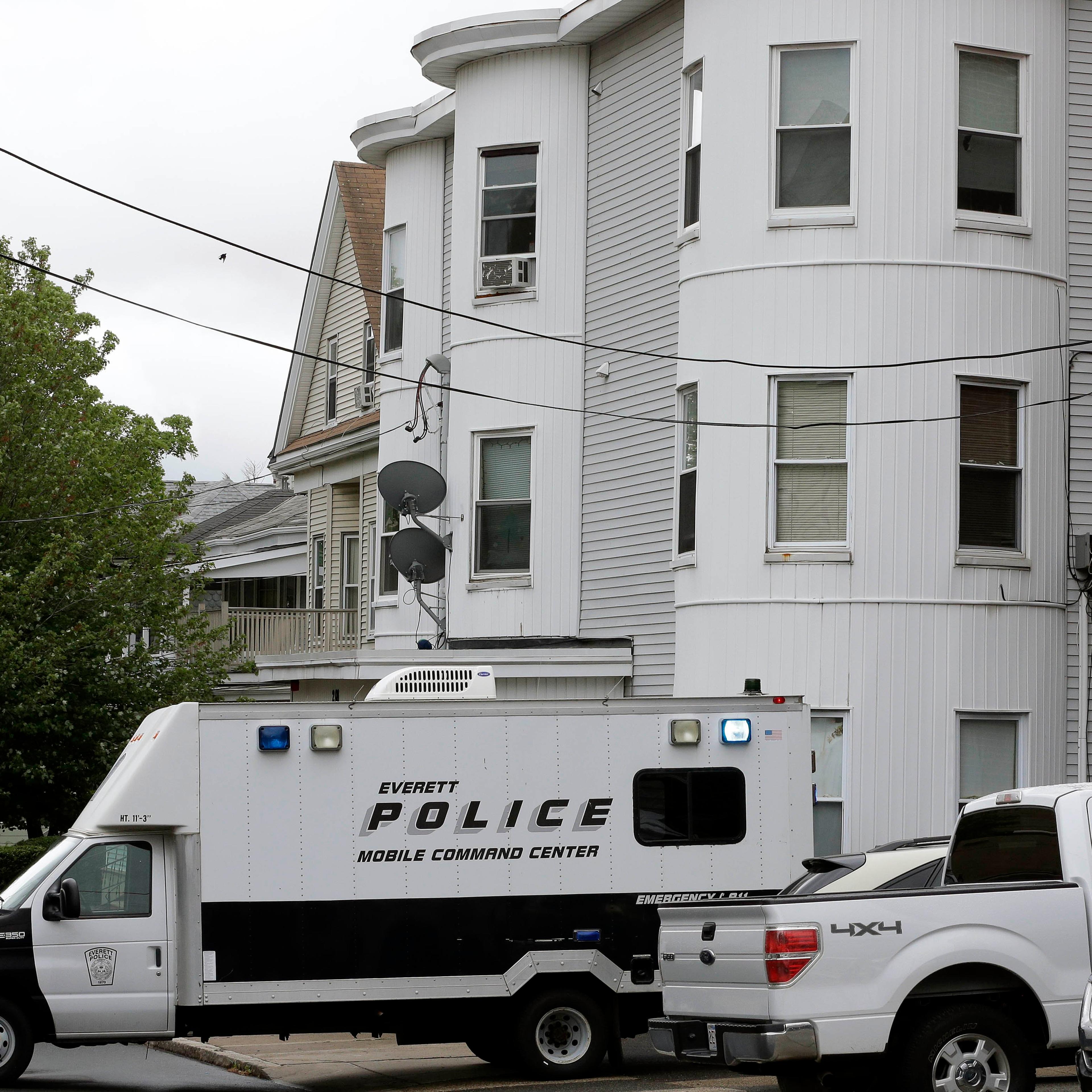 Police vehicles sit in front of a multi-storied home on June 2, 2015, in Everett, Mass., being searched by authorities in connection with a man shot and killed earlier in the day in Boston. The man, under surveillance by terrorism investigators, was kill