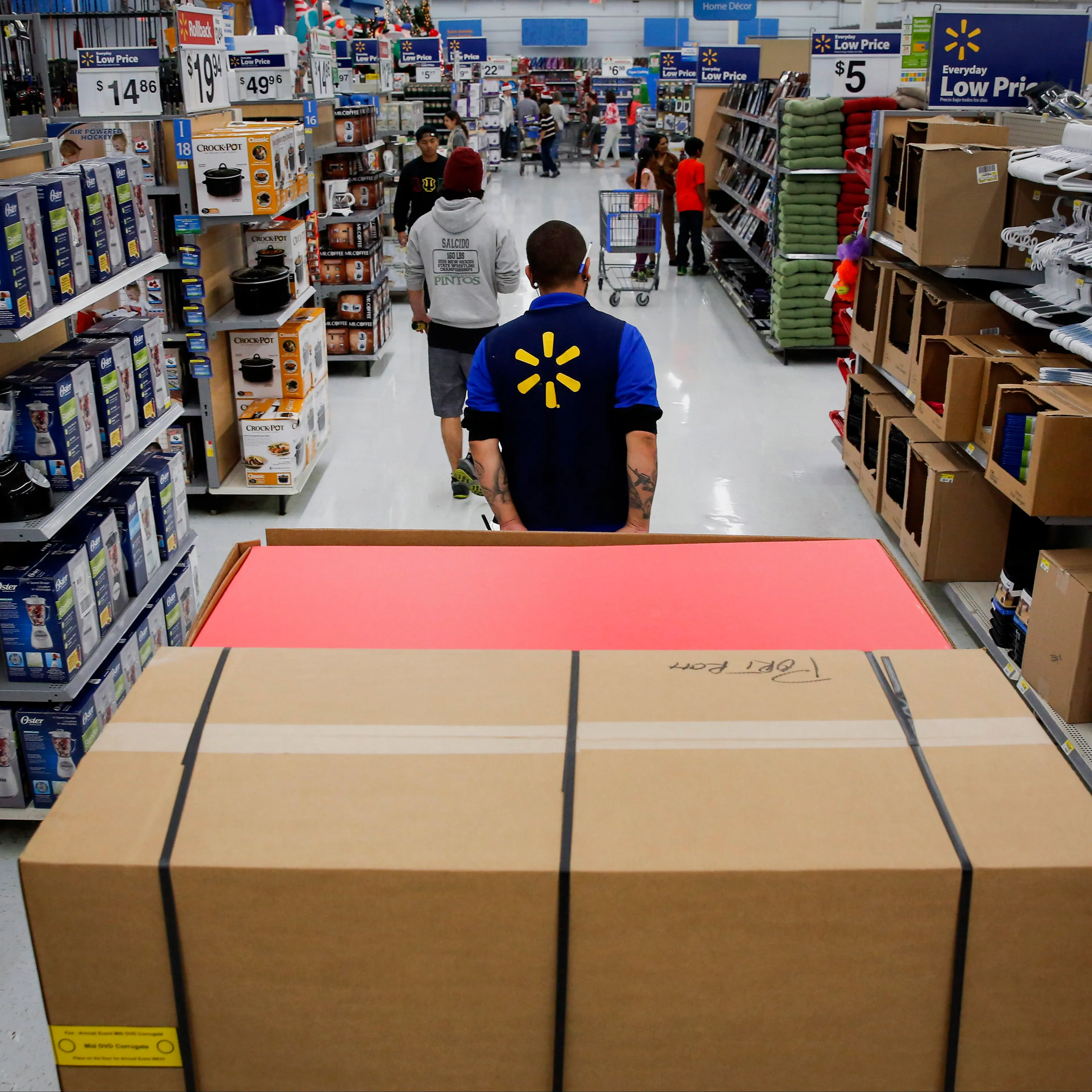 An employee pulls a forklift with display units for DVD movies at a Wal-Mart Stores Inc. location ahead of Black Friday in Los Angeles, Calif. on Nov. 24, 2014.