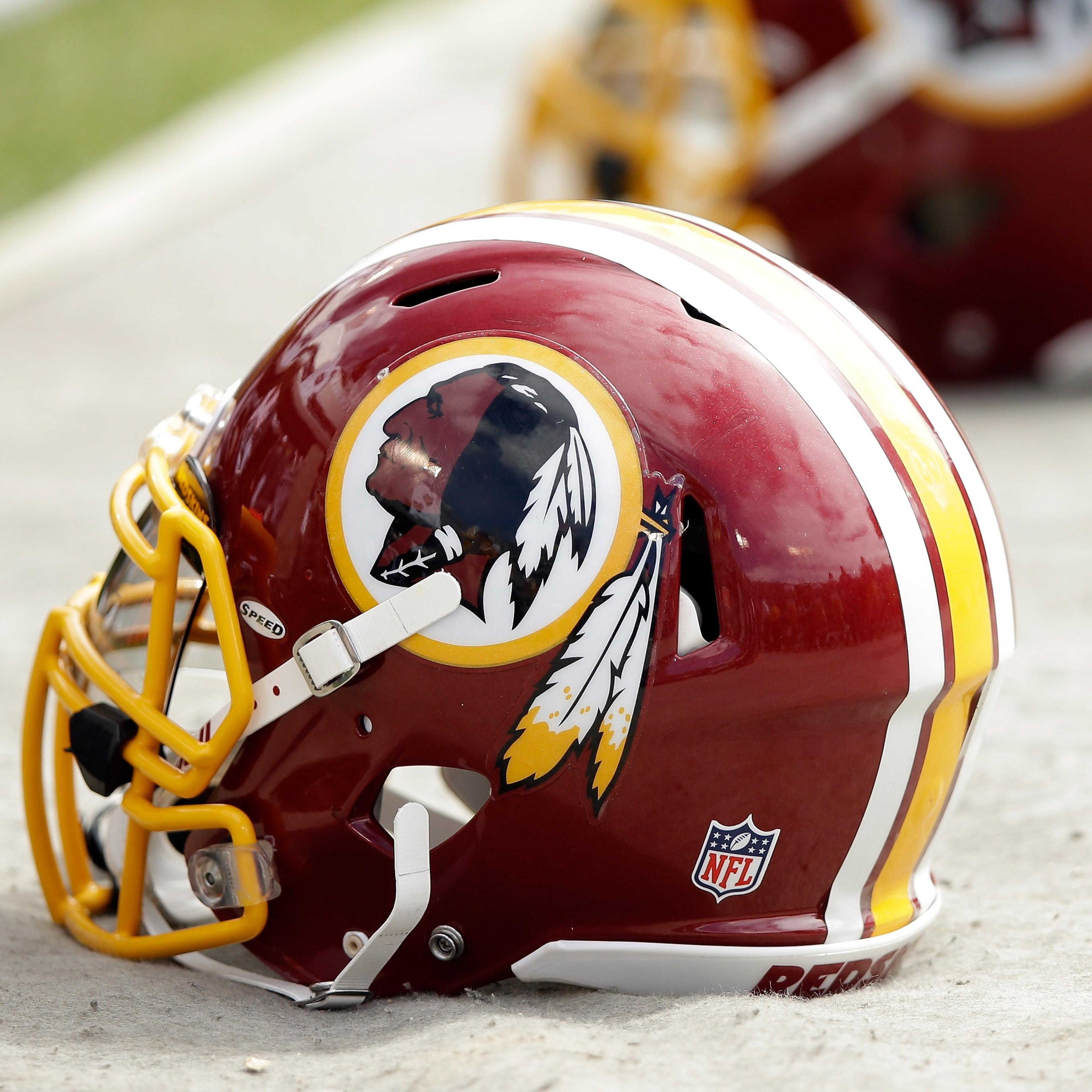Washington Redskins helmets lay on the ground during a game against the Oakland Raiders