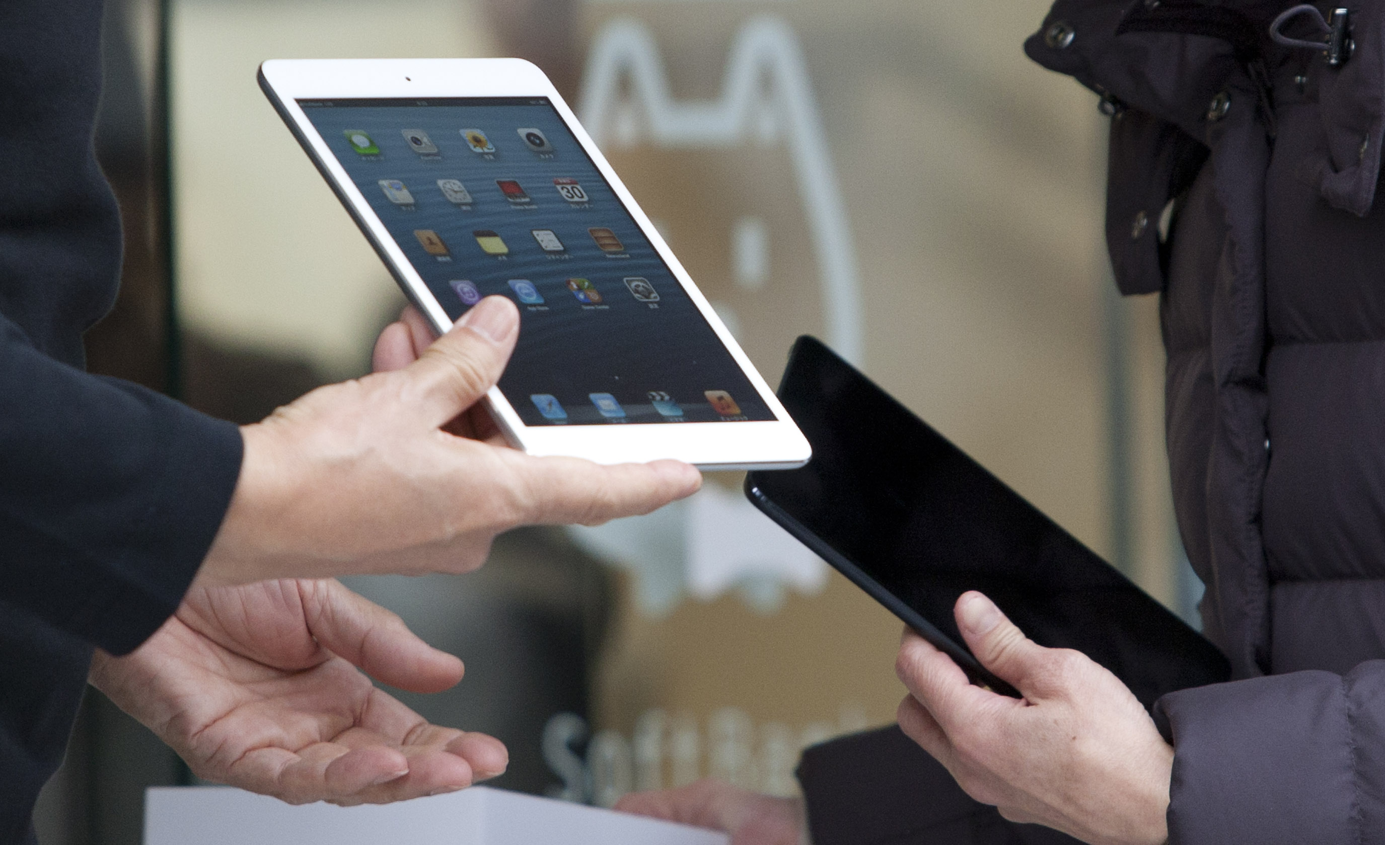 Ken Miyauchi, vice president and chief operating officer of Softbank Corp., left, holds an Apple Inc. iPad Mini during a ceremony as the device goes on sale at the Softbank store in the Ginza district of Tokyo on November 30, 2012.