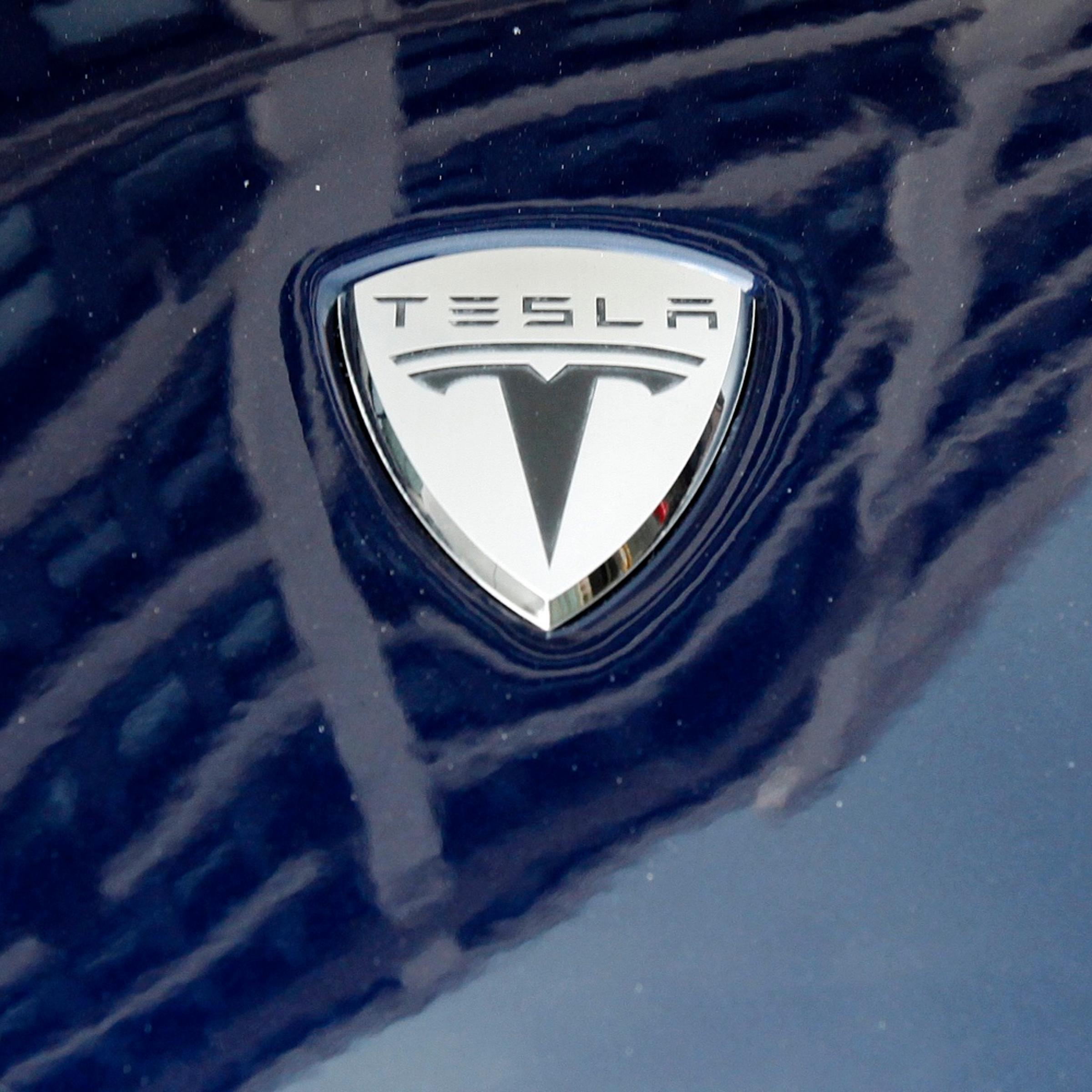 A logo of Tesla Motors on an electric car model is seen outside a showroom in New York
