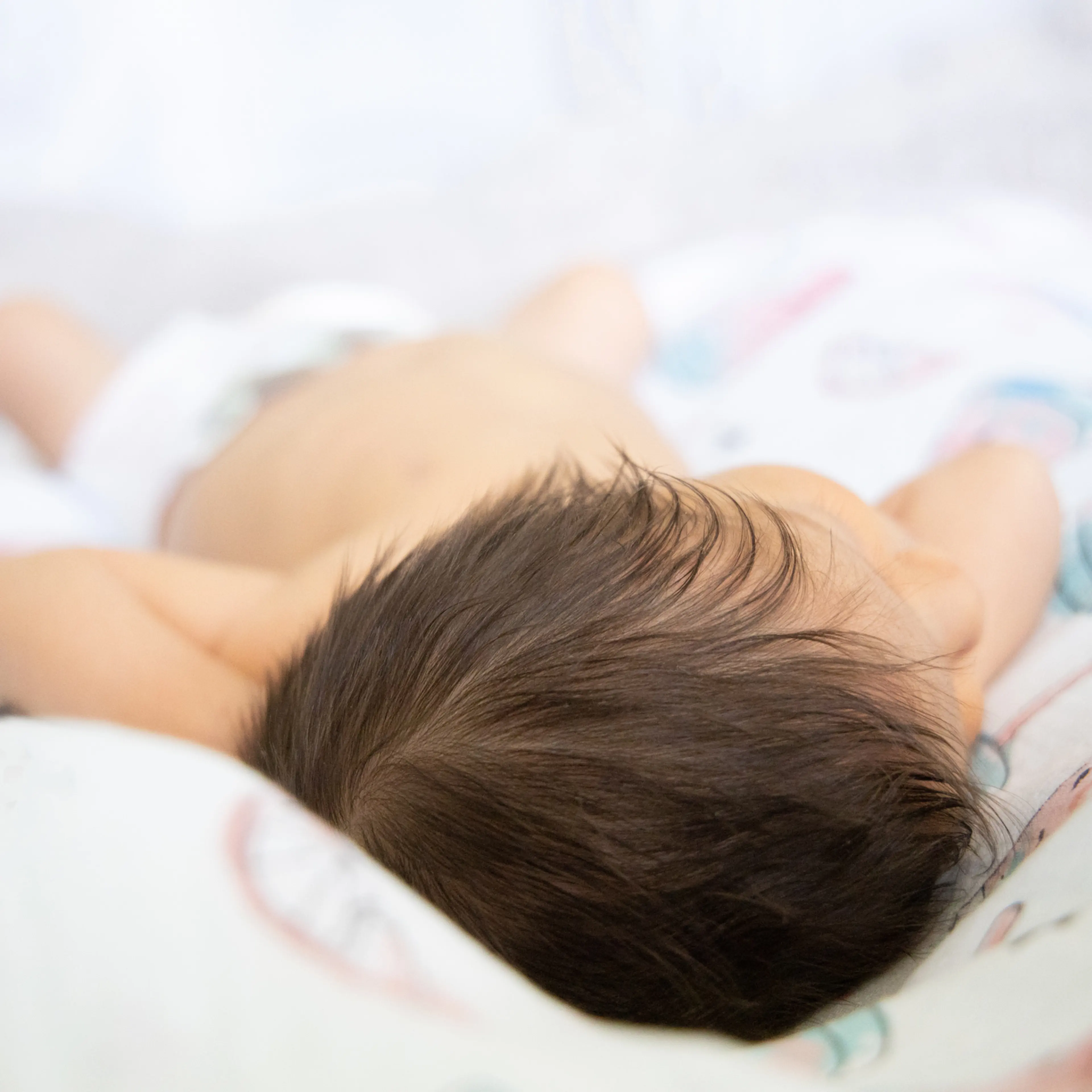Newborn Baby laying down in the bed.