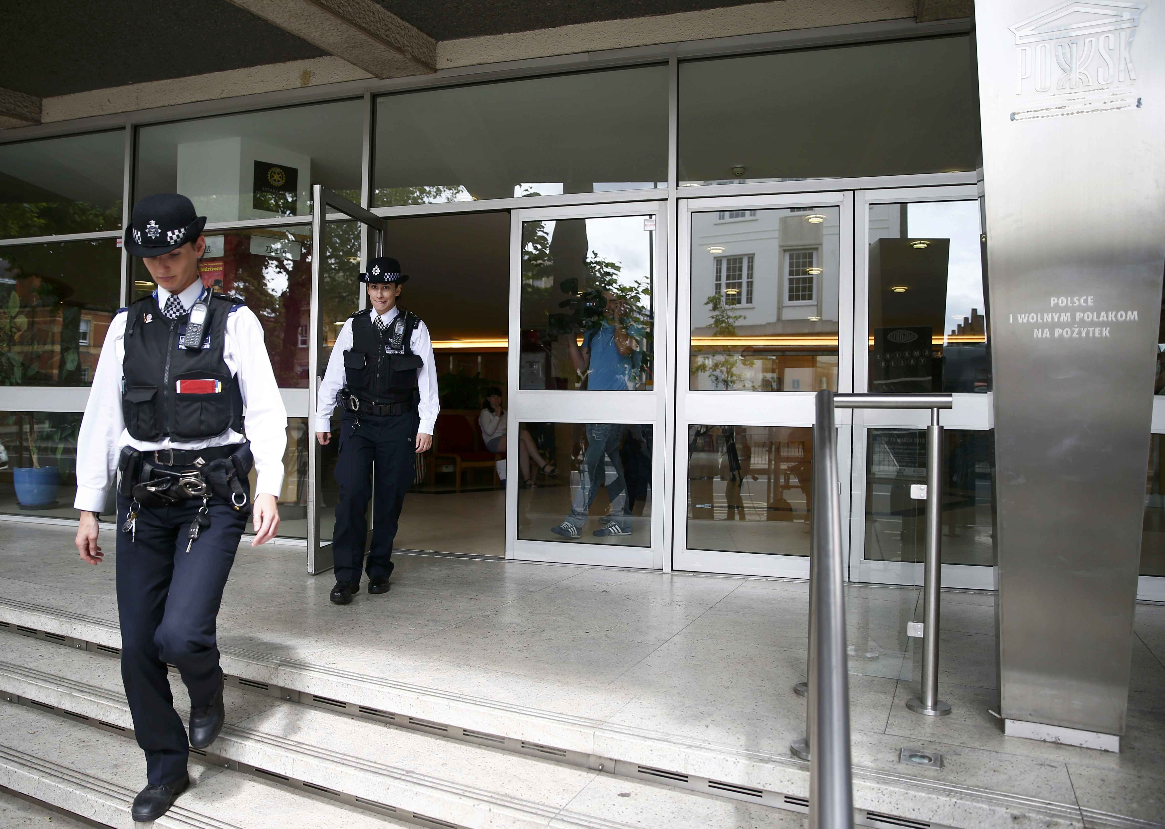 Police officers leave the Polish Social and Cultural Association after graffiti was painted on the side of the building calling on Poles to leave the United Kingdom, in Hammersmith, London