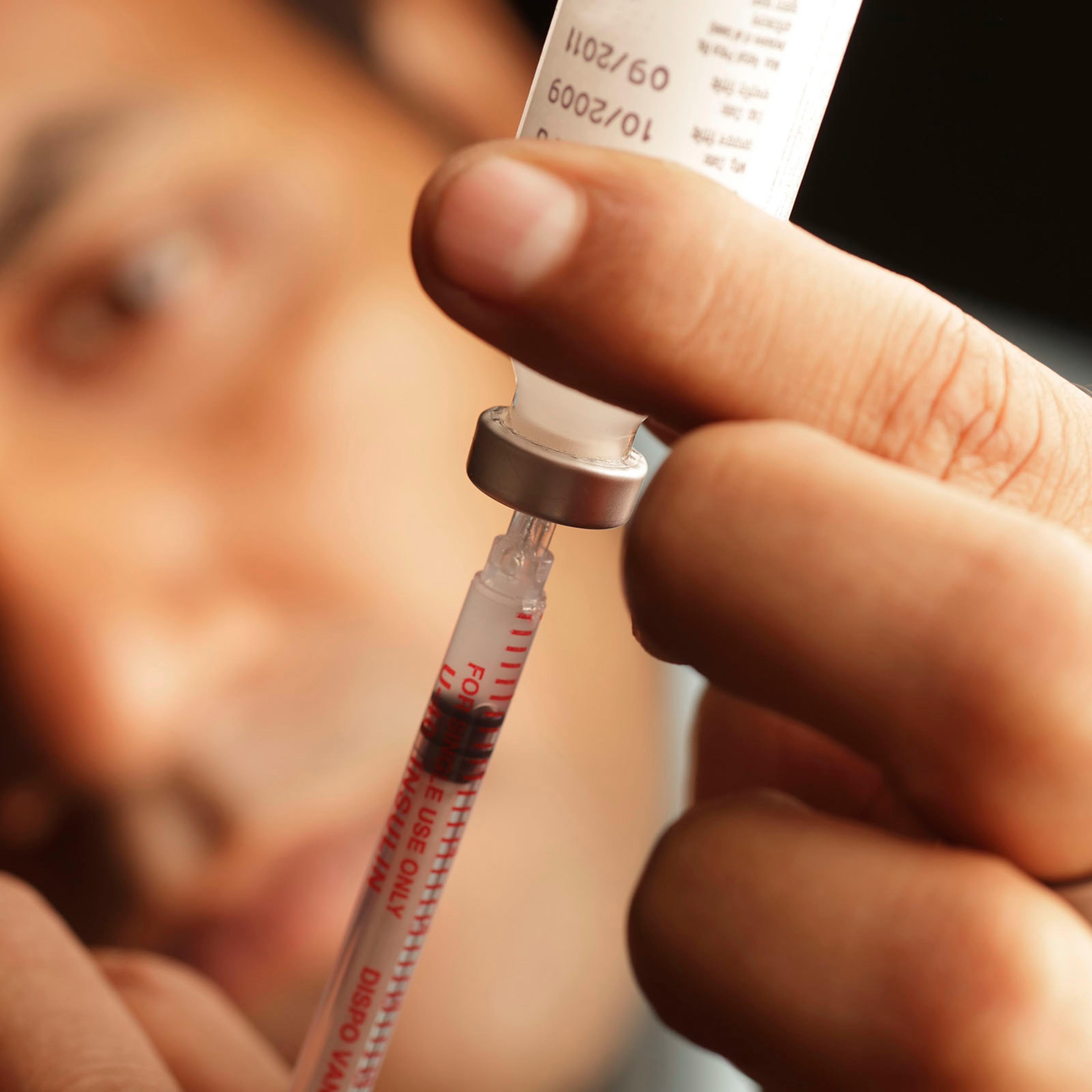 A male loading insulin into a needle