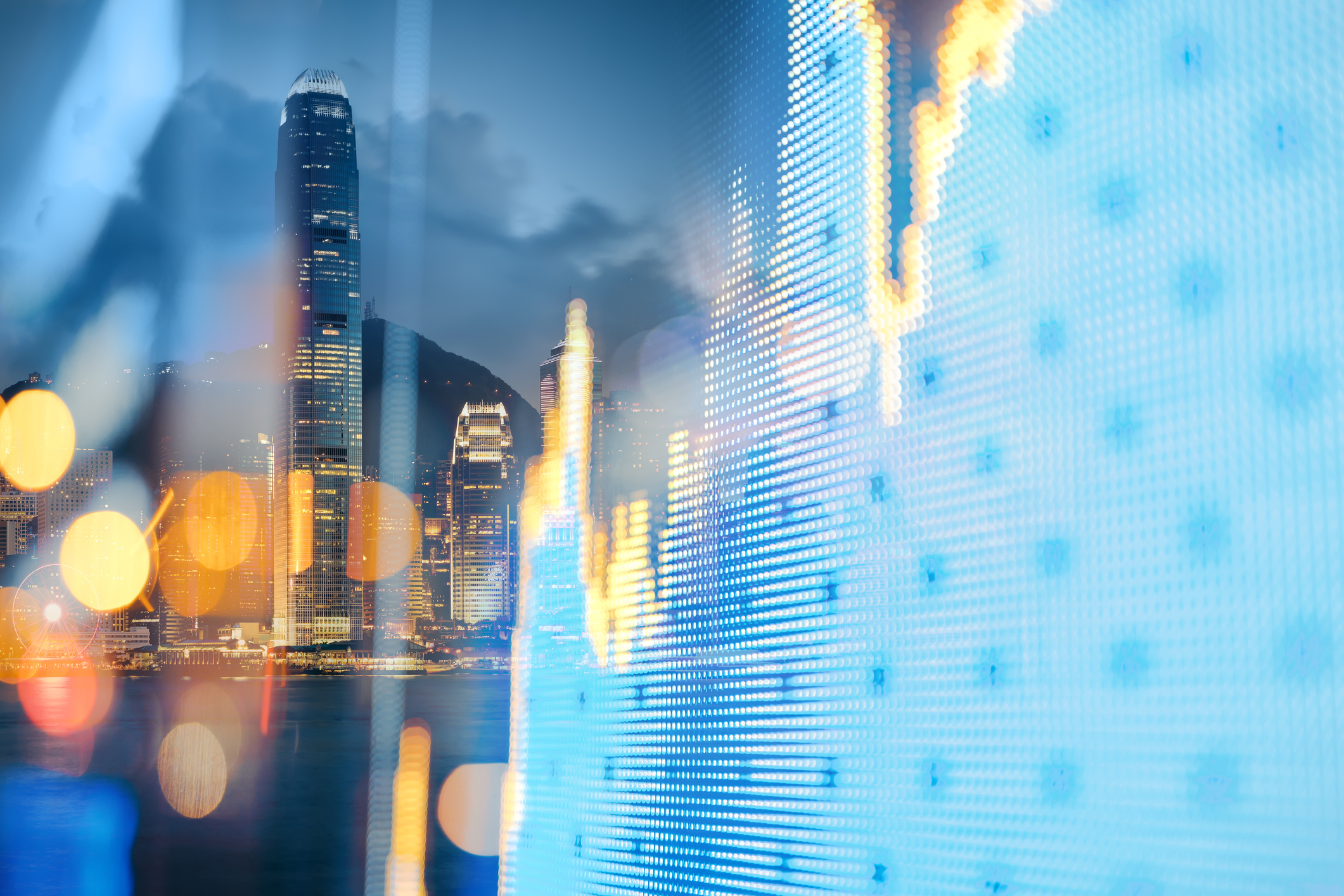 The Hong Kong cityscape behind a financial display board.