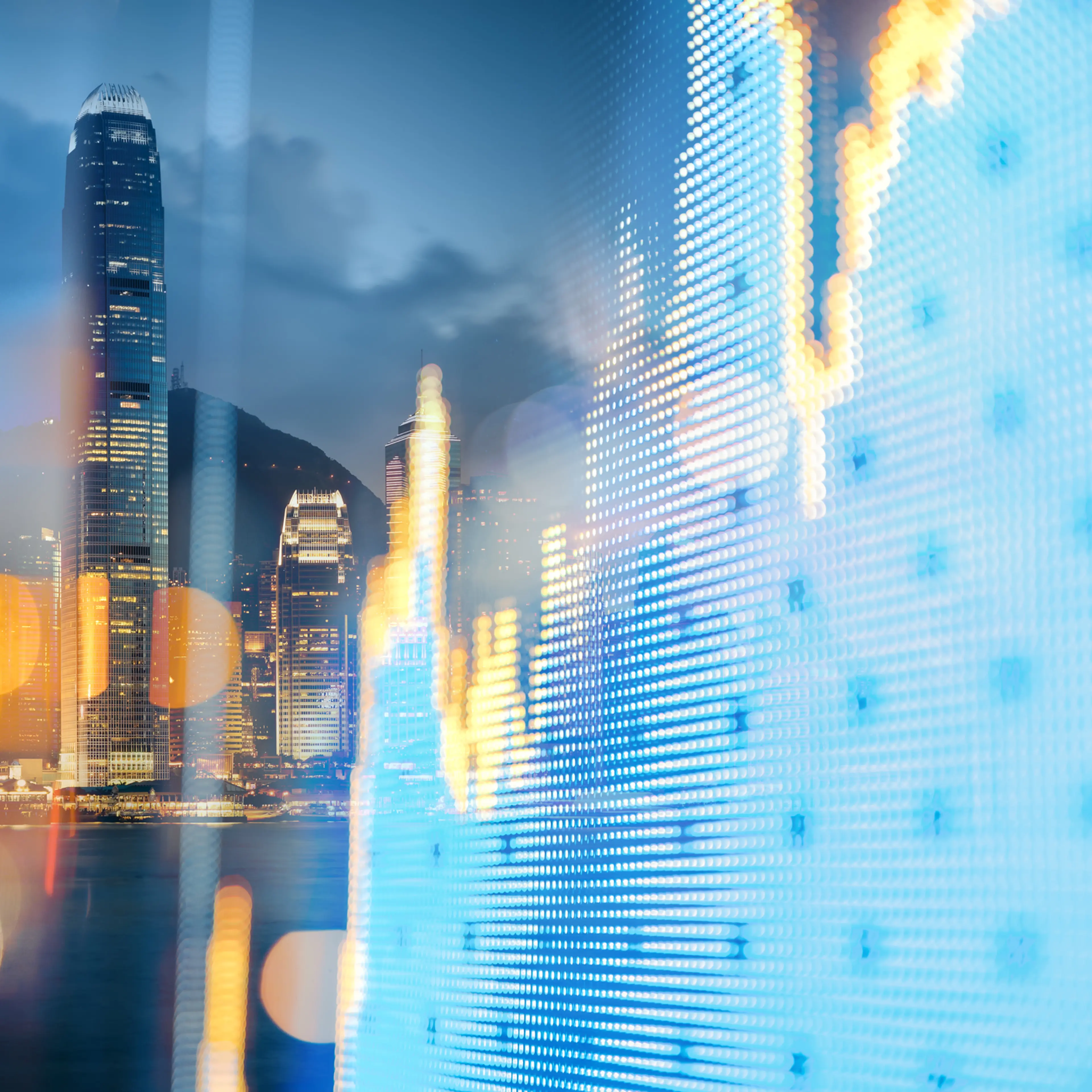 The Hong Kong cityscape behind a financial display board.