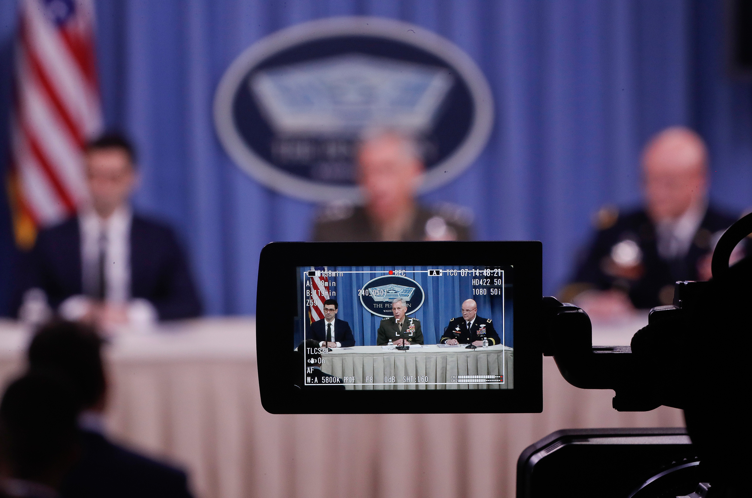 From left, Assistant Secretary of Defense for International Security Affairs Robert S. Karem, Marine Gen. Thomas D. Waldhauser and Army Maj. Gen. Roger L. Cloutier are seen through a television camera viewfinder while briefing members of the media at the