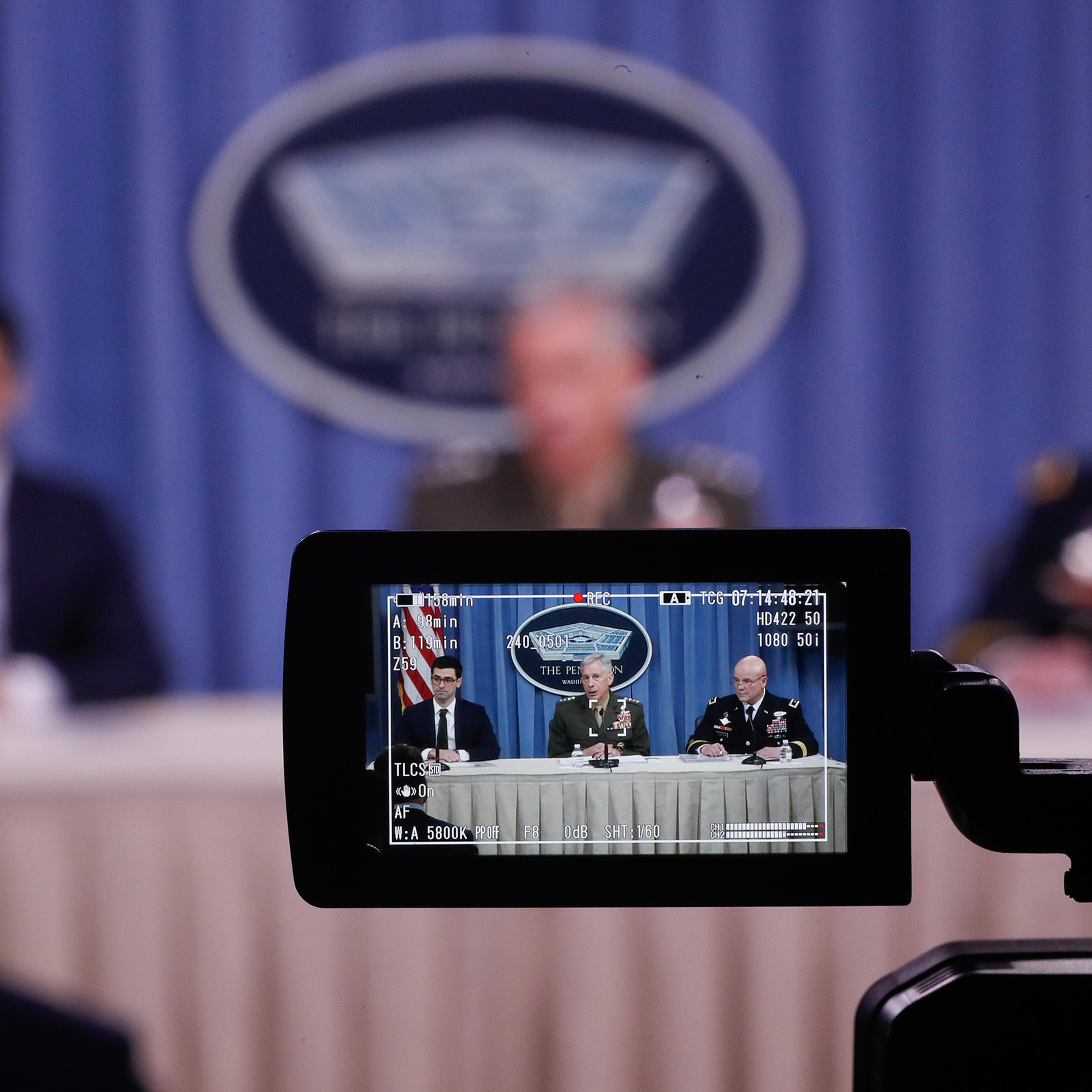 From left, Assistant Secretary of Defense for International Security Affairs Robert S. Karem, Marine Gen. Thomas D. Waldhauser and Army Maj. Gen. Roger L. Cloutier are seen through a television camera viewfinder while briefing members of the media at the