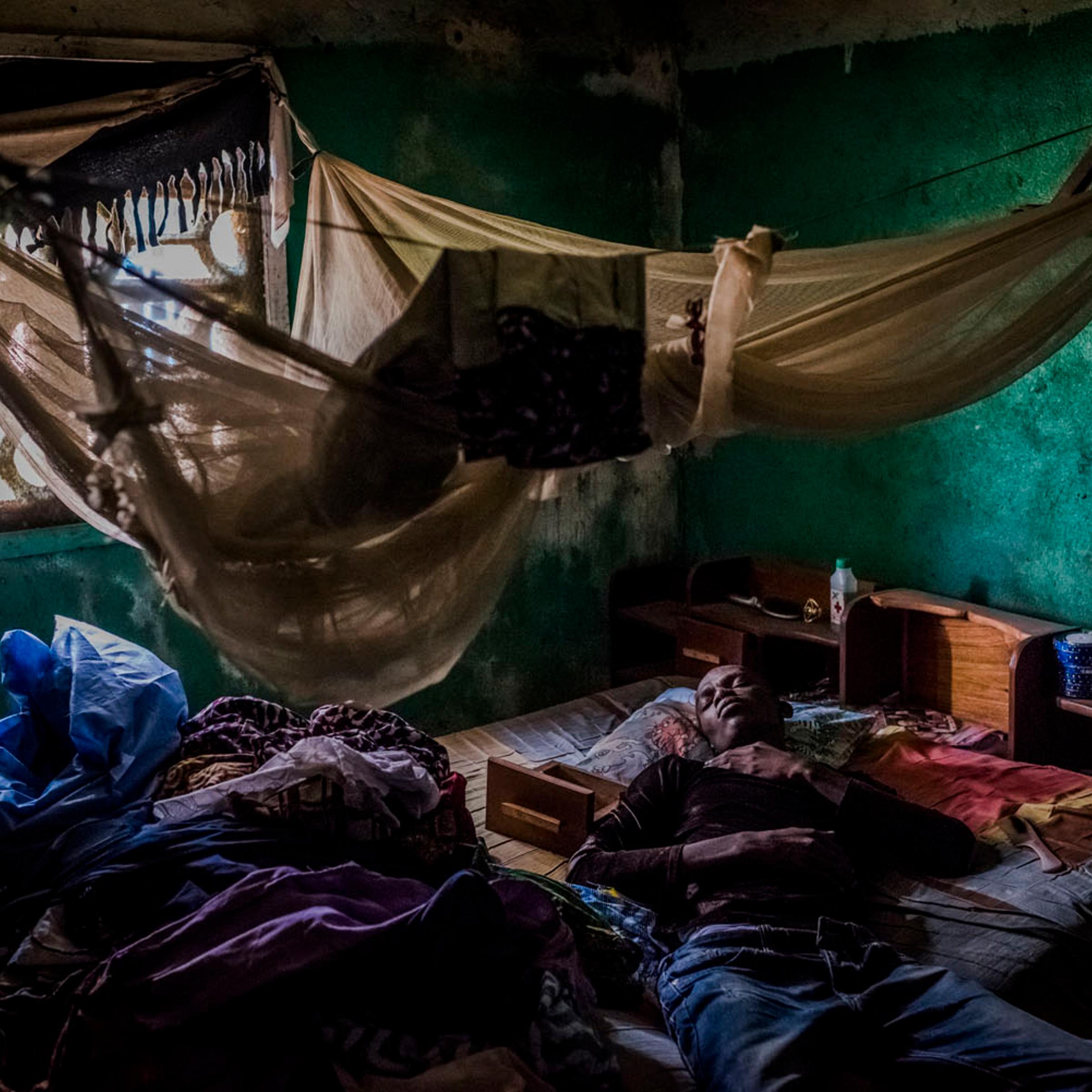 Mark Jerry, who along with his adopted daughter was turned away from an Ebola clinic a day prior, rests at his grandmother?s home in Monrovia, Liberia.