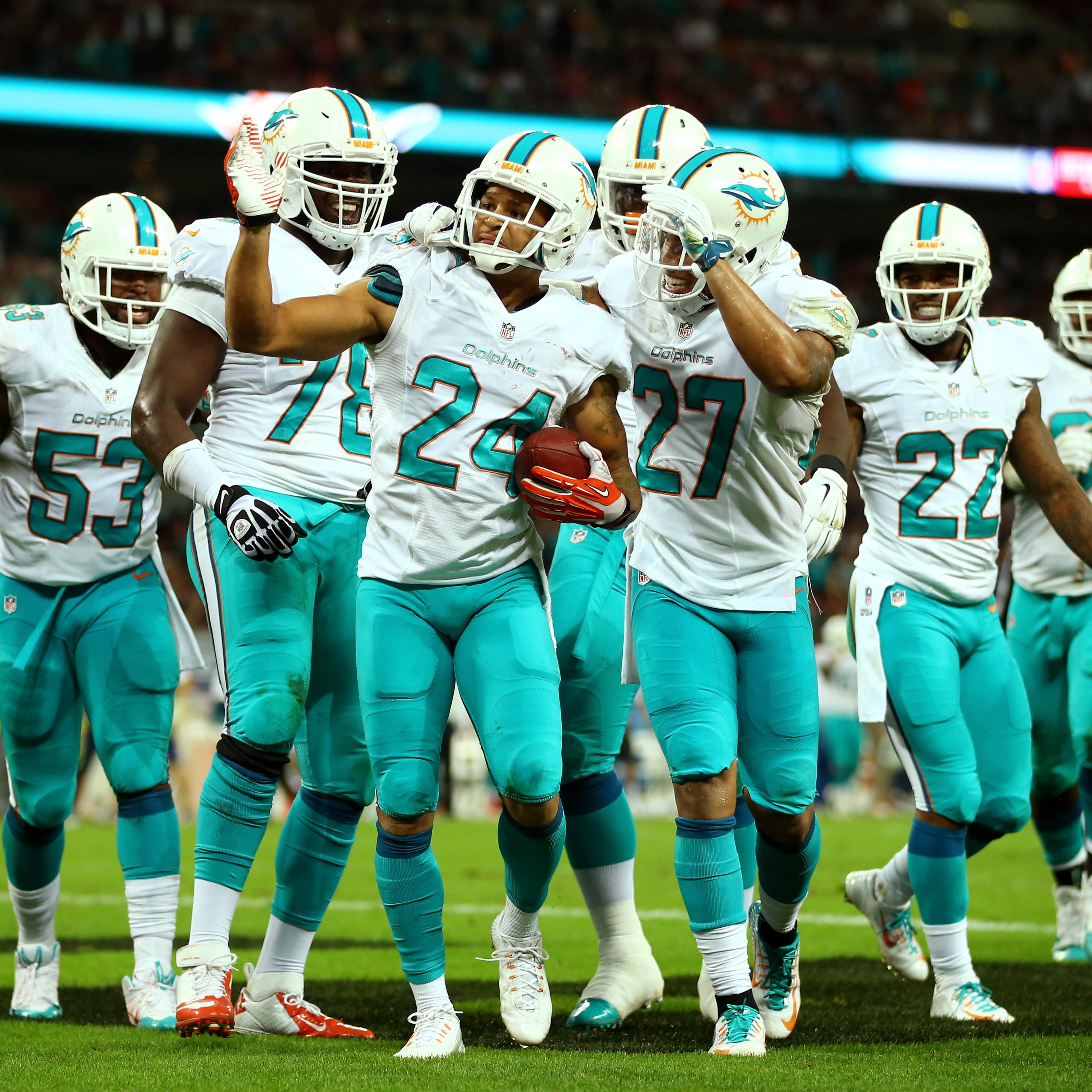 Cortland Finnegan of the Miami Dolphins celebrates with teammates after returning a fumble 50 yards to score a touchdown during the NFL match between the Oakland Raiders and the Miami Dolphins at Wembley Stadium on Sept. 28, 2014 in London,