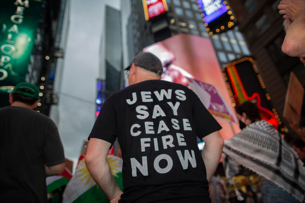 A demonstrator wearing a t-shirt with Jews Says Cease Fire